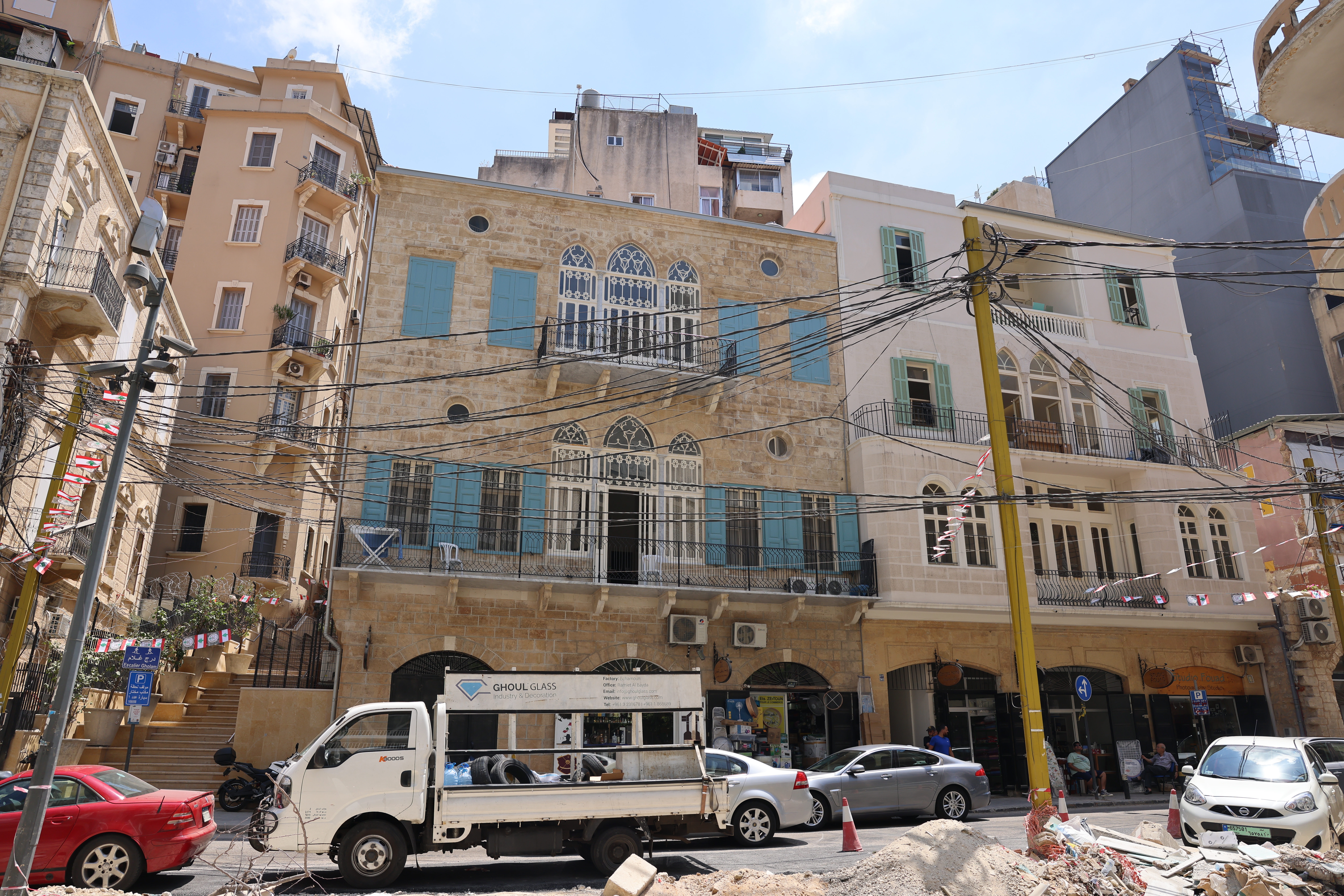 People drive past newly restored historic buildings