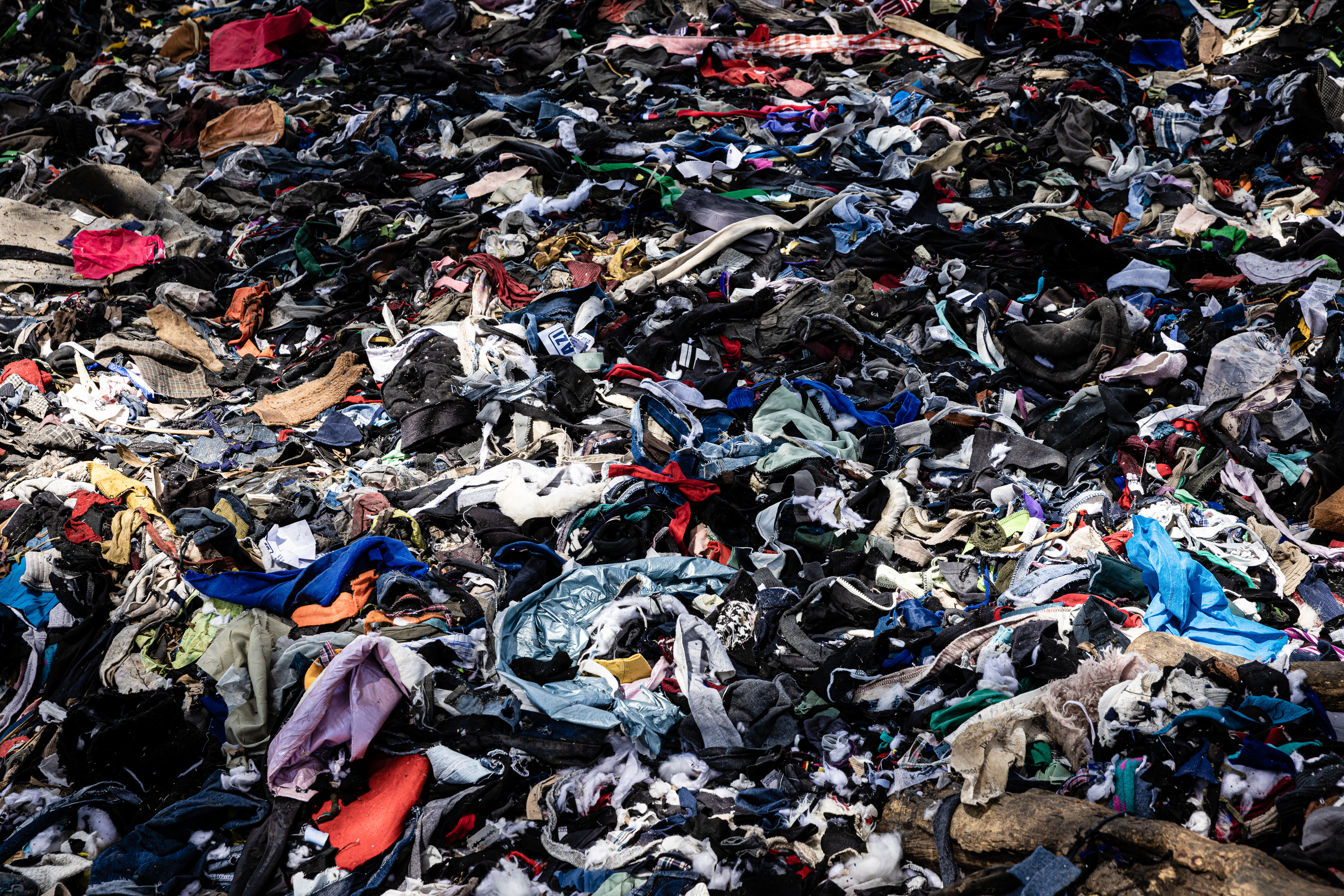 Mounds of unsold secondhand clothing that is damaged or worn-out is discarded on the shores of the Nairobi River outside Gikomba market.