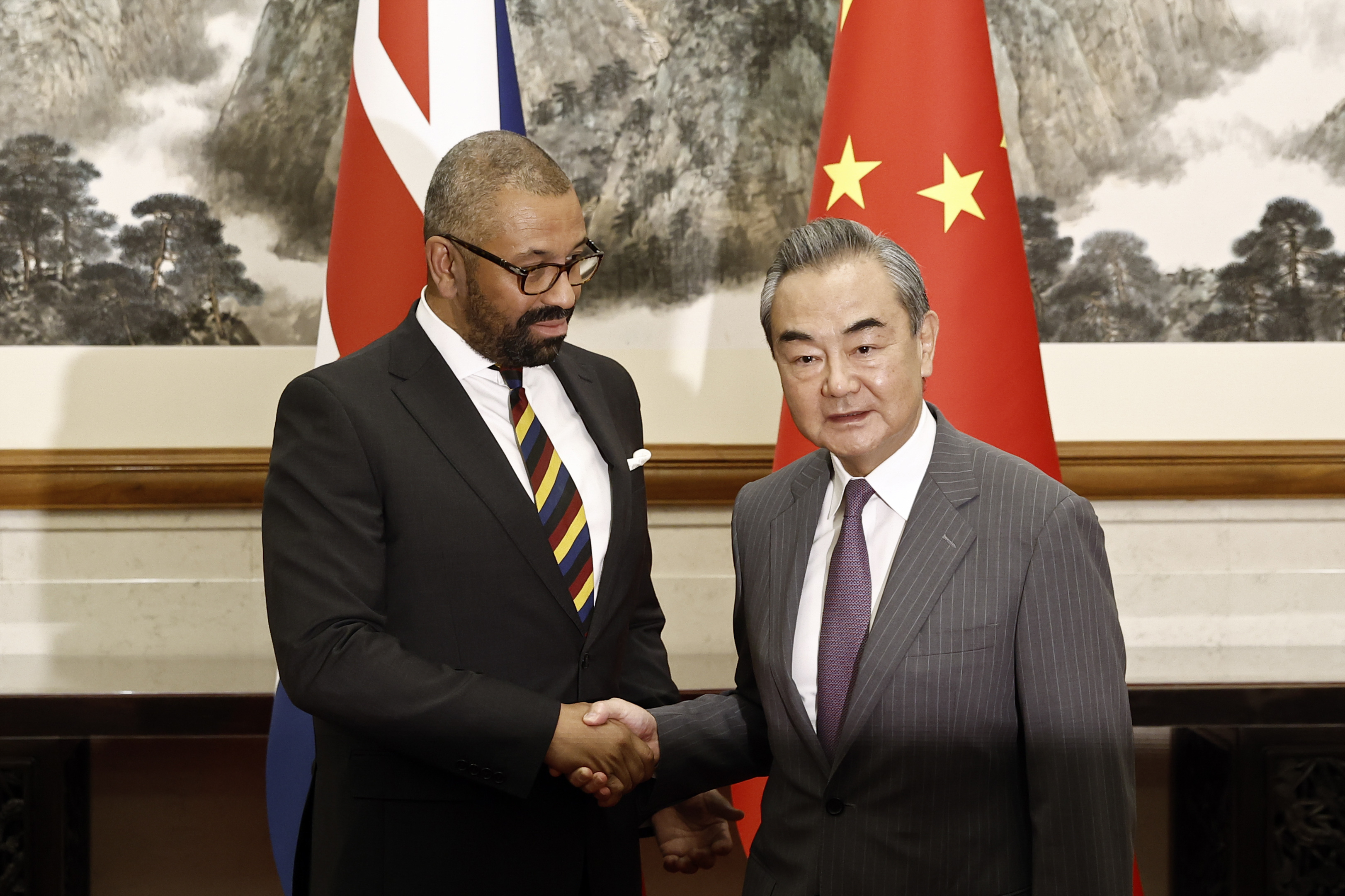 British Foreign Secretary James Cleverly, left, and Chinese Foreign Minister Wang Yi shake hands before a meeting at the Diaoyutai State Guesthouse in Beijing