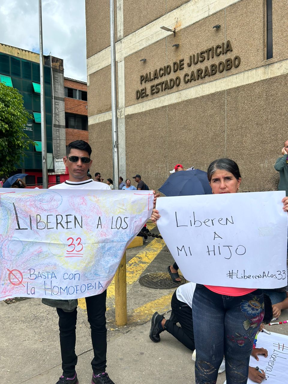 Protesters hold up signs that say ‘Free the 33’ and ‘Free my son’ outside of a court in Carabobo, Venezuela [Courtesy of Yendri Velasquez]