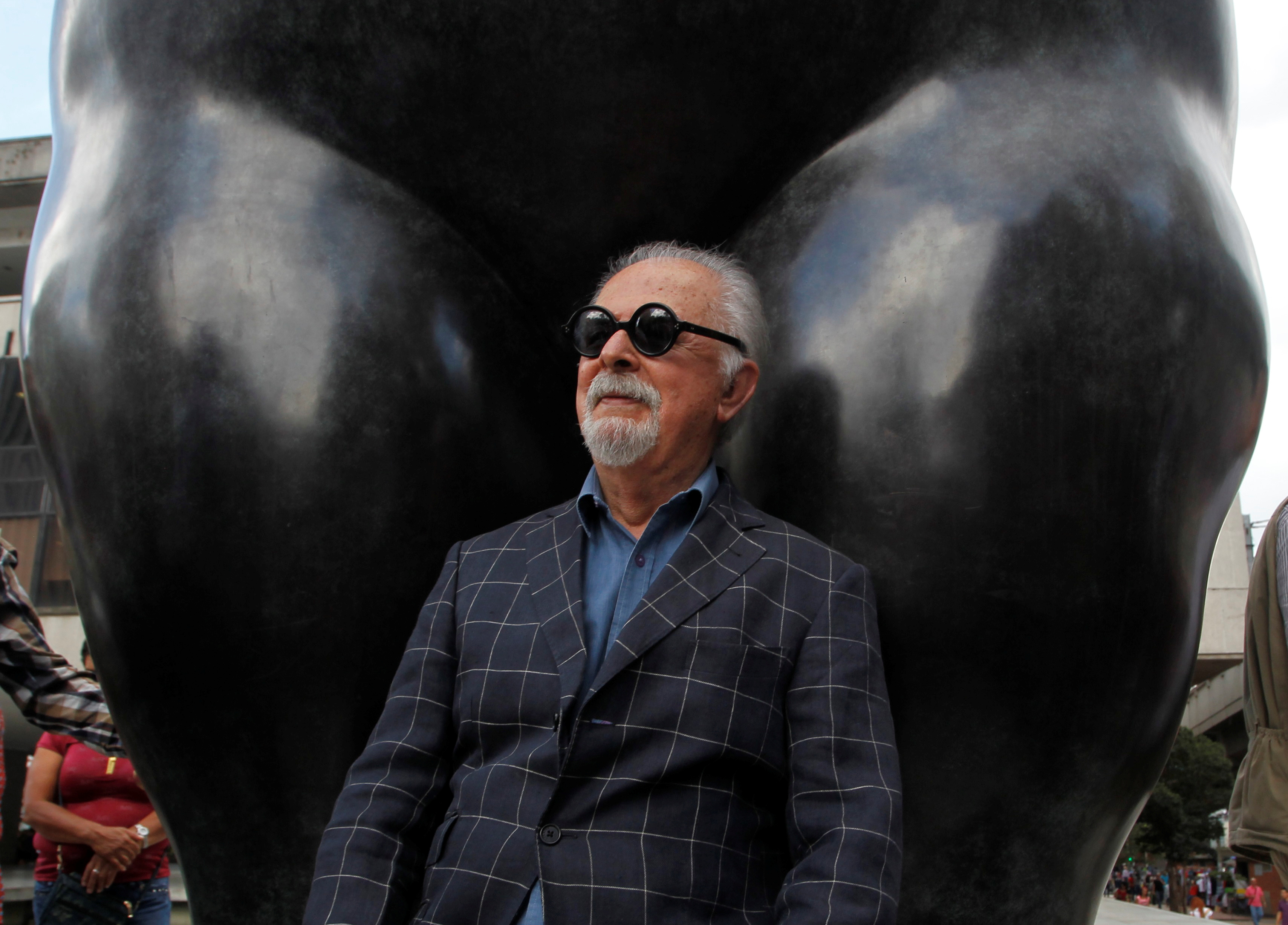 Botero sits underneath one of his sculptures in Medellin, Colombia, in 2017