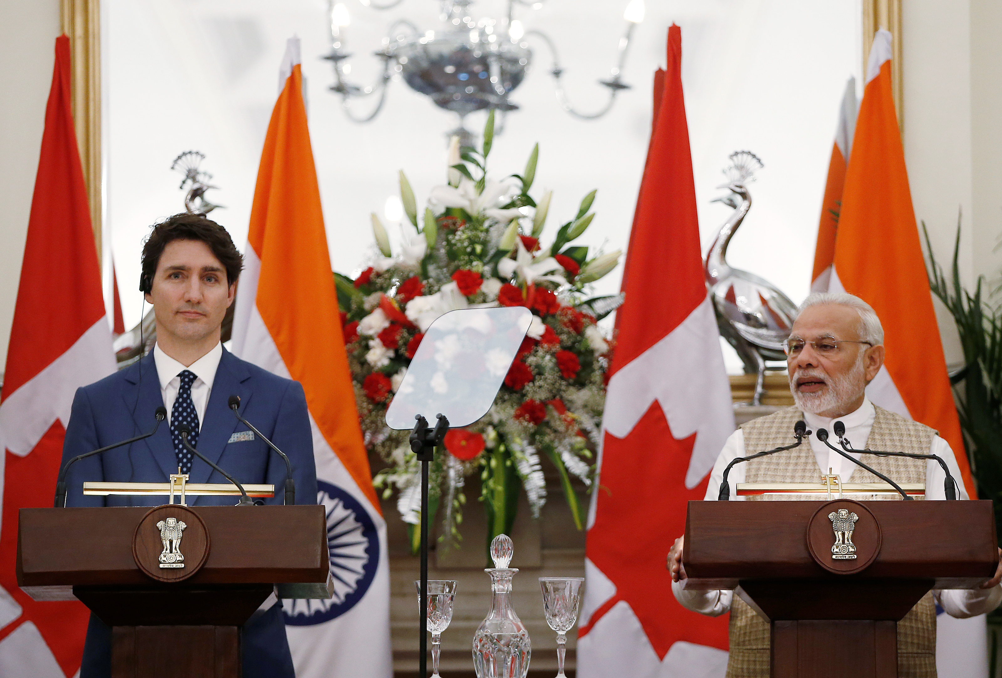 Indian Prime Minister Narendra Modi (R) reads a joint statement as his Canadian counterpart Justin Trudeau looks on at Hyderabad House in New Delhi
