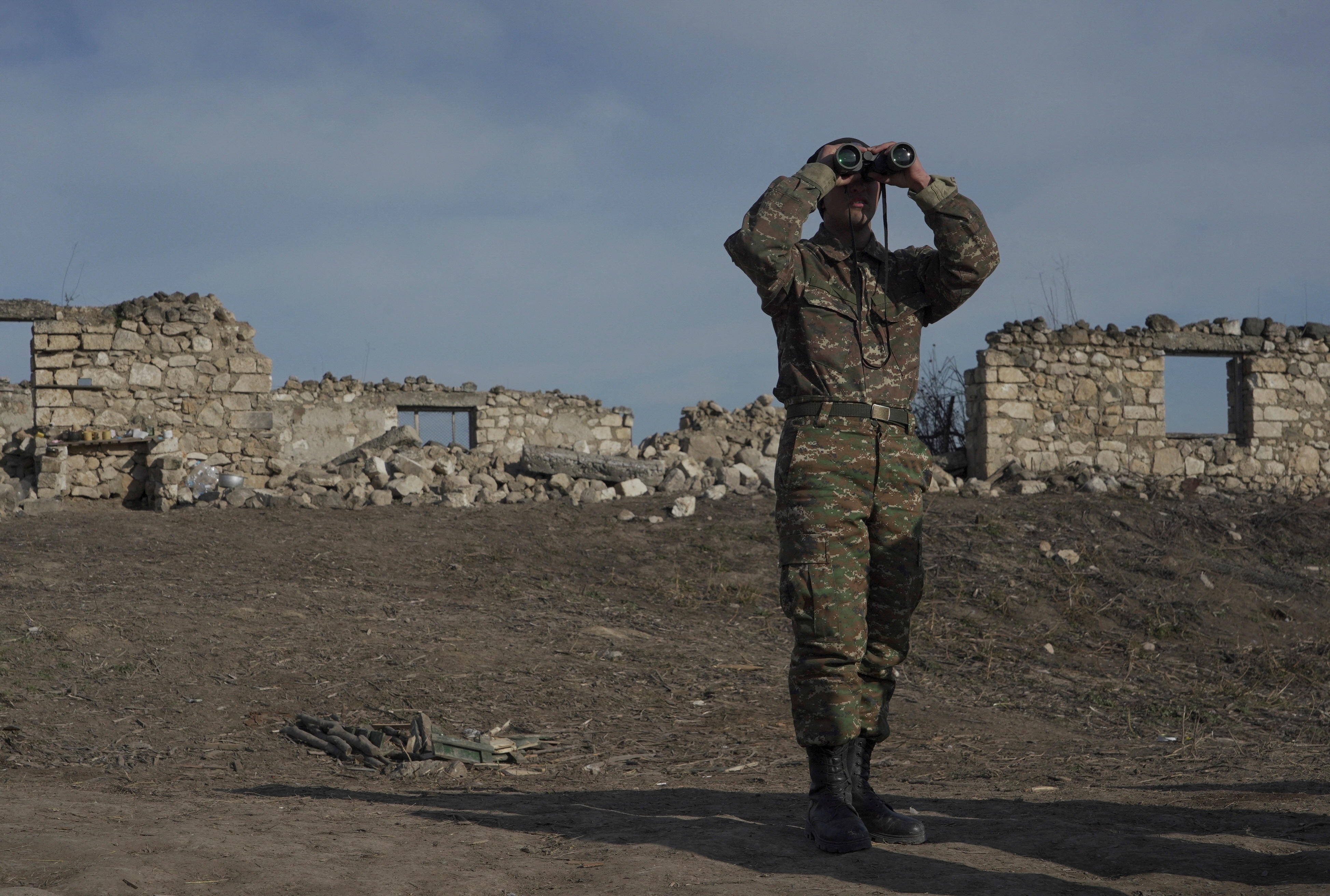 An Armenian soldier looks through binoculars at a fighting position in Nagorno-Karabakh in January 2021