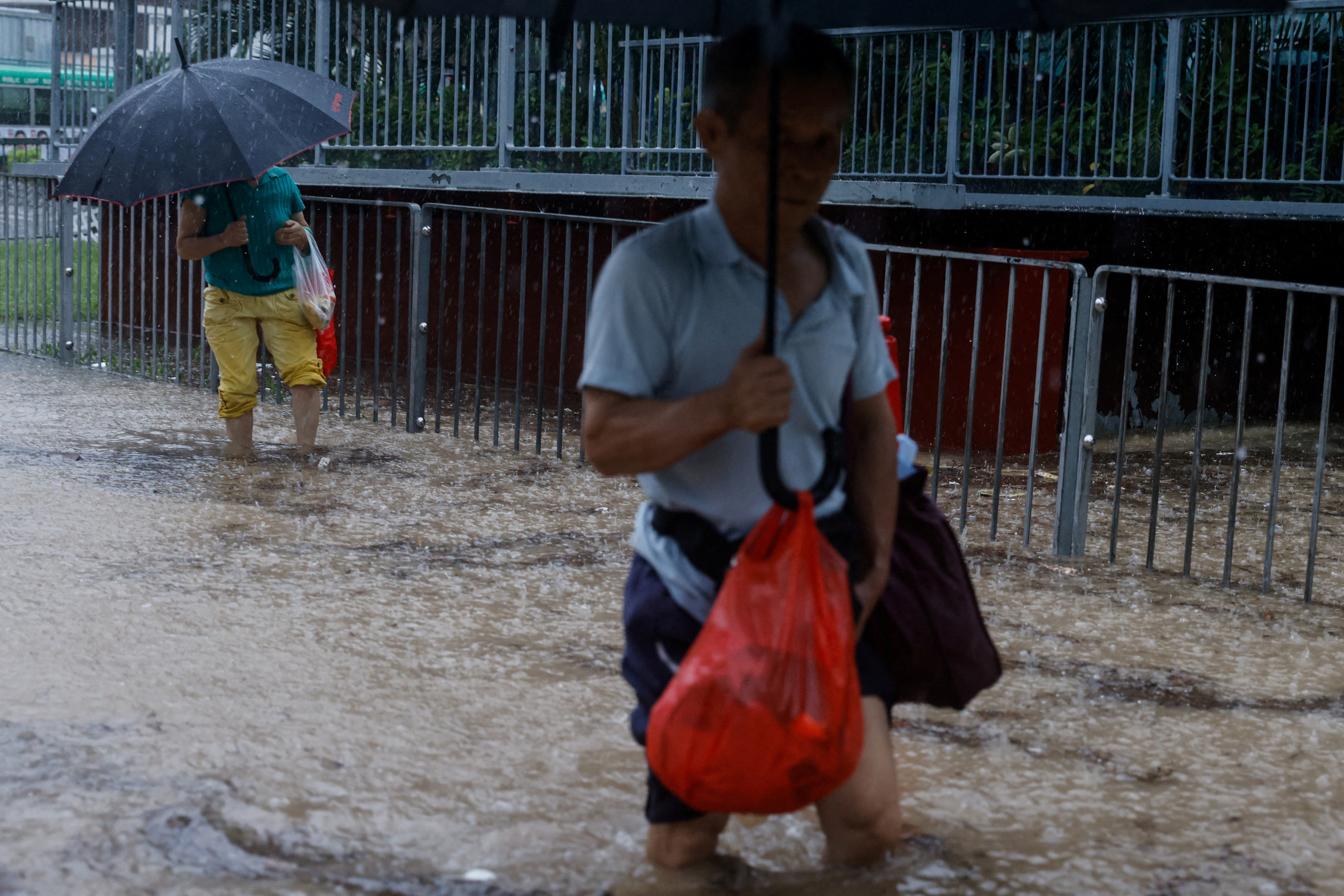 People walking through floods waters in Hong Kong
