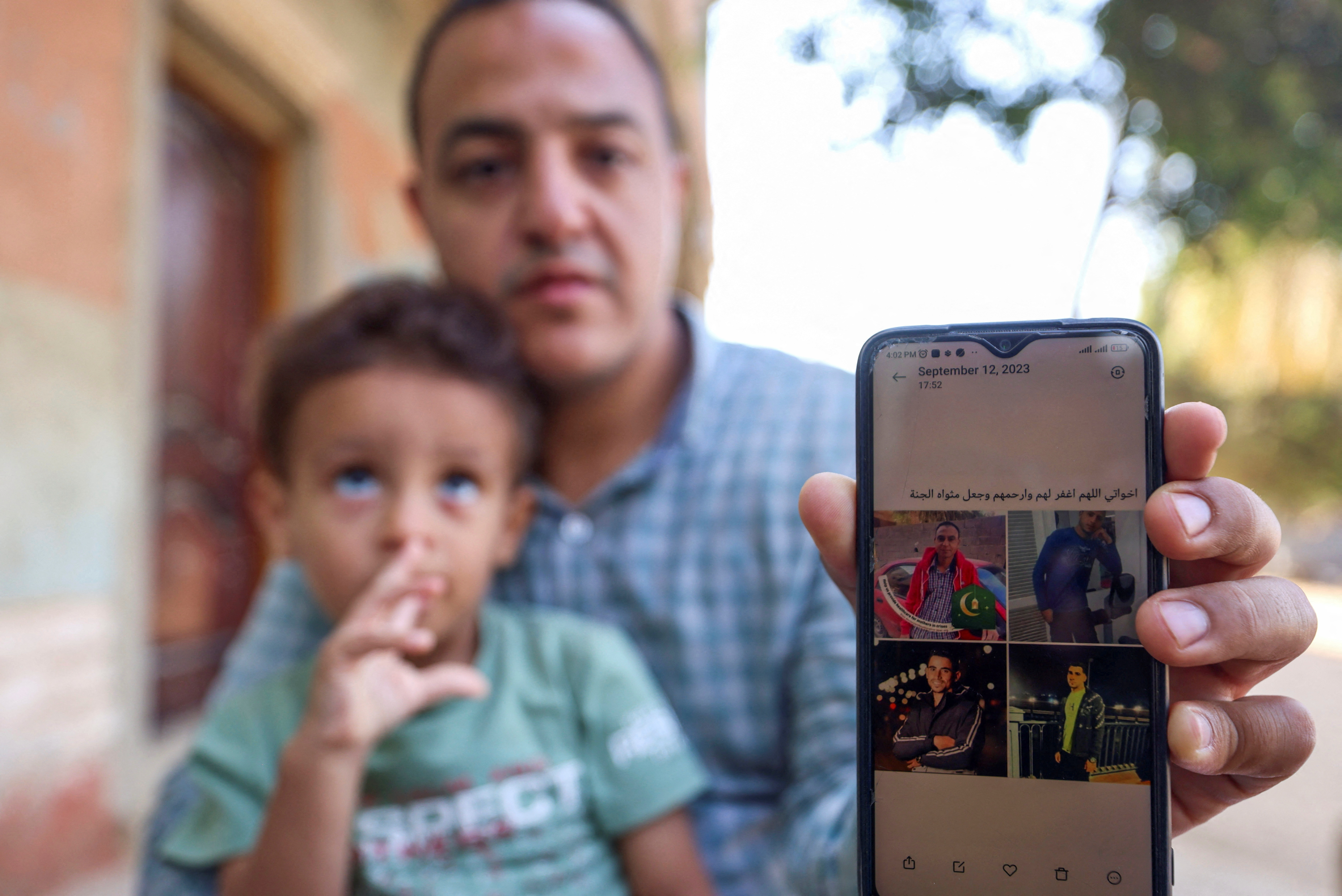 A man shows photos of his relatives who died in Libya after Storm Daniel hit the country, at Al Sharief village in Bani Swief province, Egypt