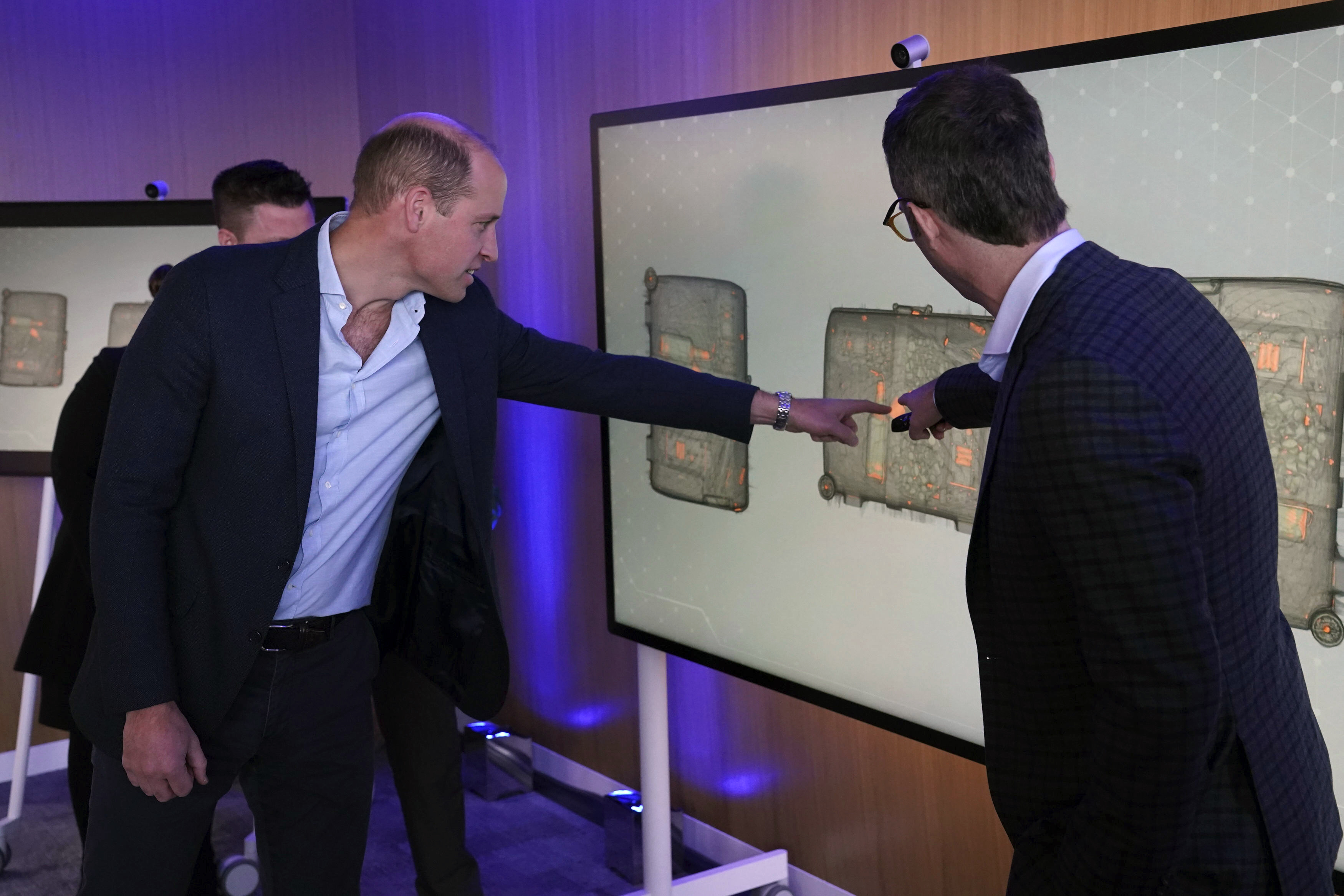 Britain's Prince William, left, looks for ivory hidden in a suitcase on a scan during his visit to Microsoft HQ to learn how new AI scanning technology can increase detection of illegal wildlife products being trafficked through international airports, in Reading, England, Thursday Nov. 18, 2021. (Steve Parsons/Pool Photo via AP)
