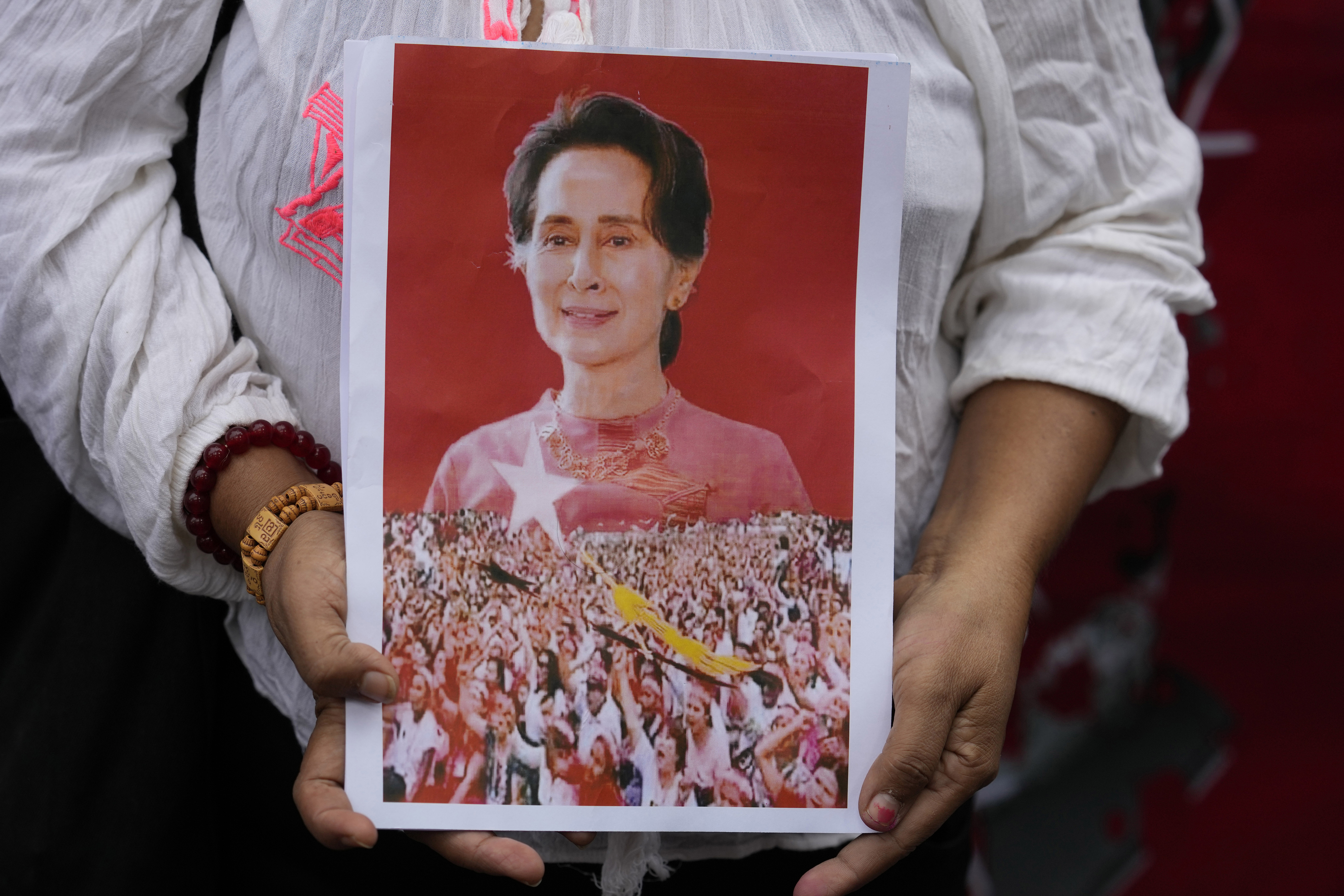 A supporter holding a framed portrait of Aung San Suu Kyi