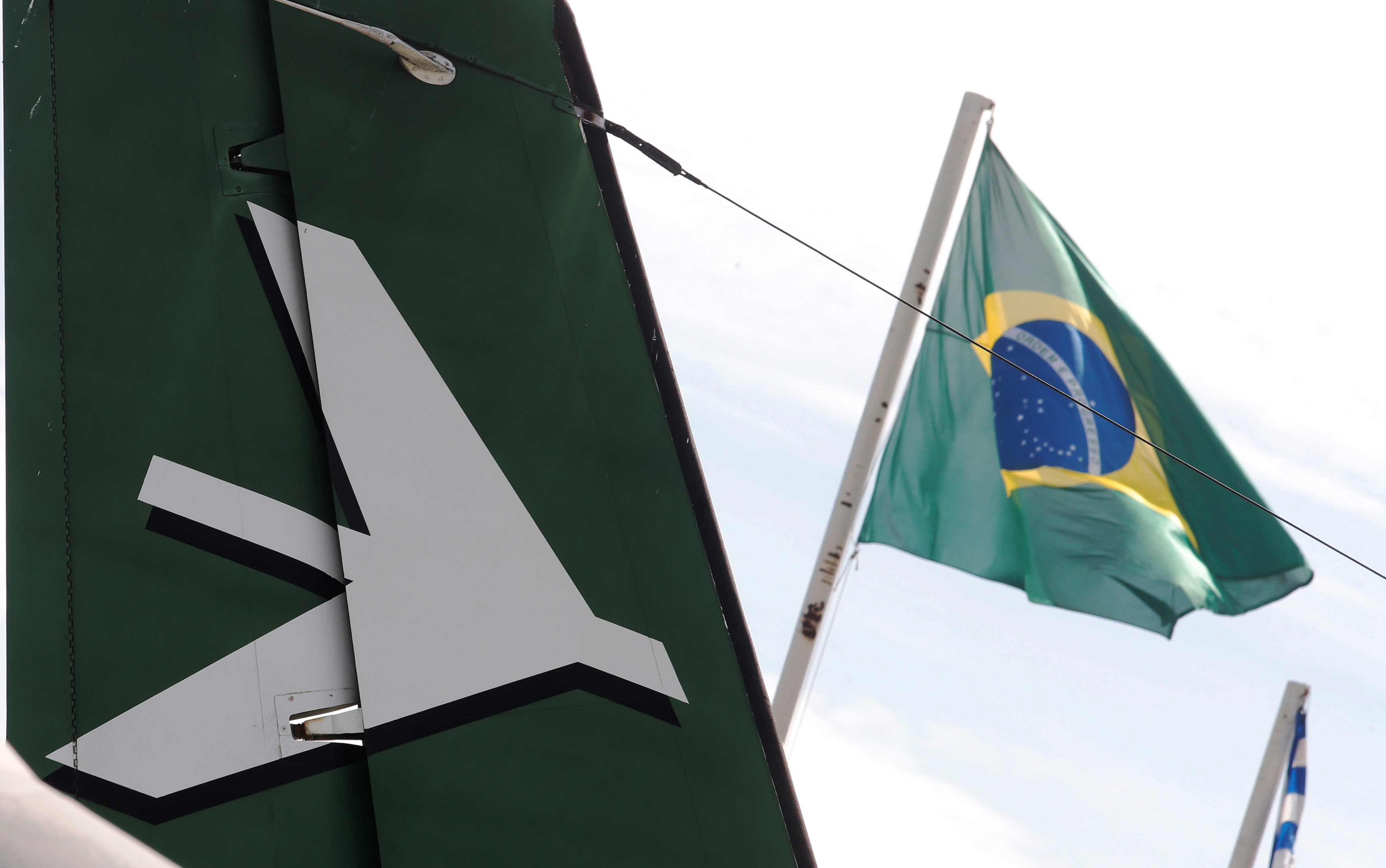 A Brazilian flag is seen behind an Embraer Bandeirante's tail