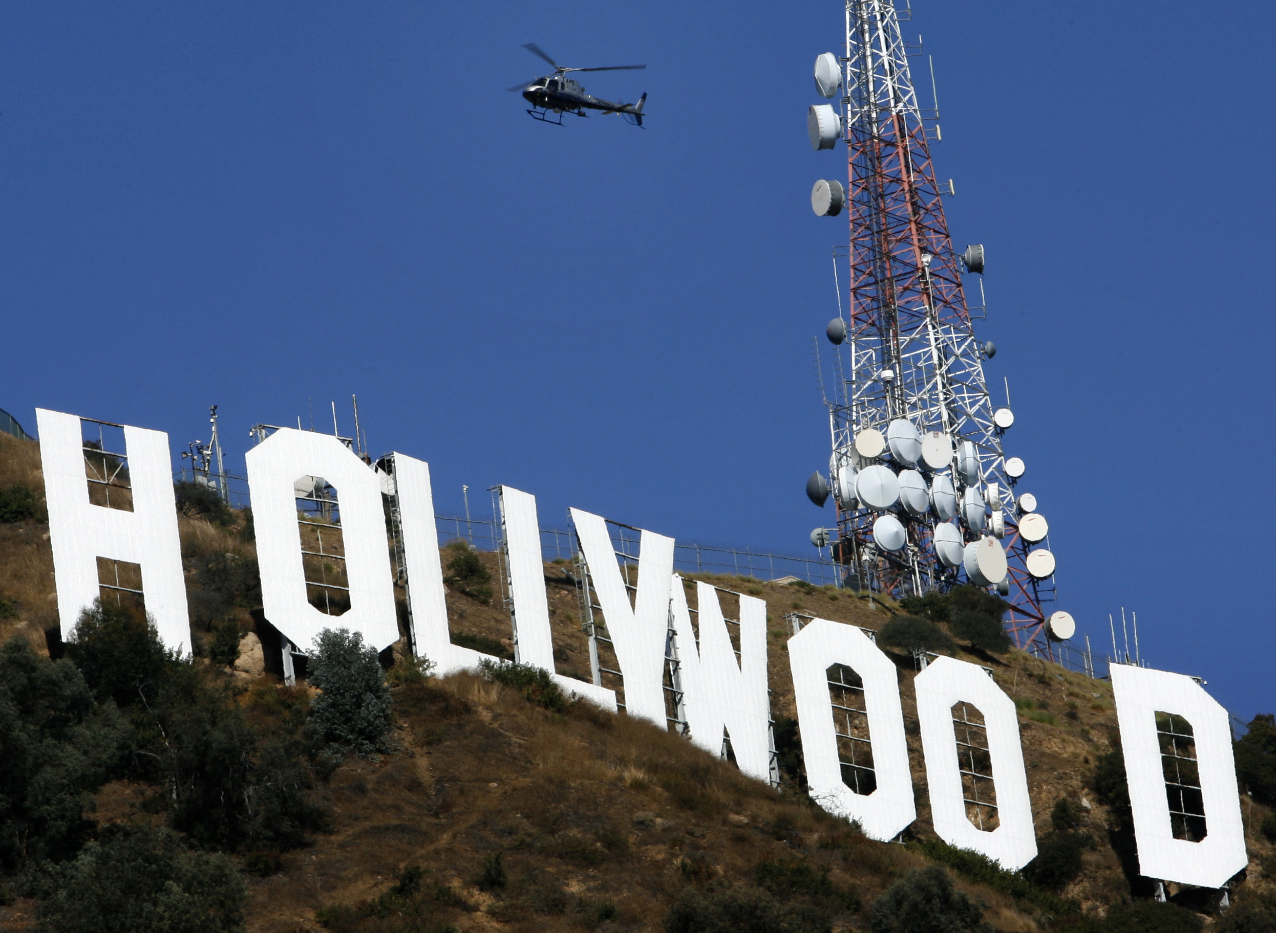 A Los Angeles Police Department helicopter surveys the Hollywood sign in Hollywood, California October 22, 2006. [File: Lucy Nicholson]