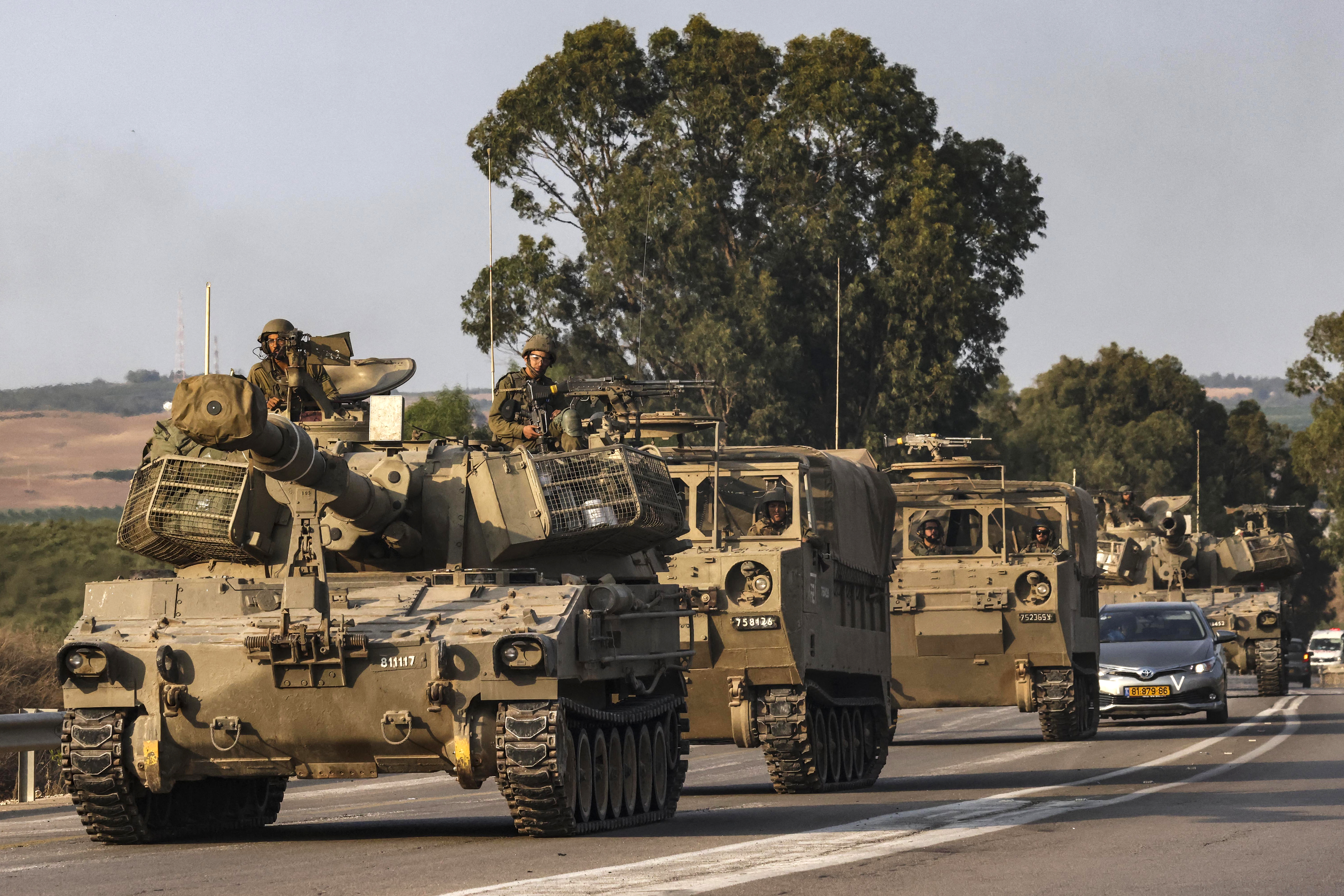 An Israeli self-propelled howitzer rolls on a highway near the southern city of Sderot on October 8, 2023. Israel's prime minister of October 8 warned of a "long and difficult" war, as fighting with Hamas left hundreds killed on both sides after a surprise attack on Israel by the Palestinian militant group. (Photo by RONALDO SCHEMIDT / AFP)