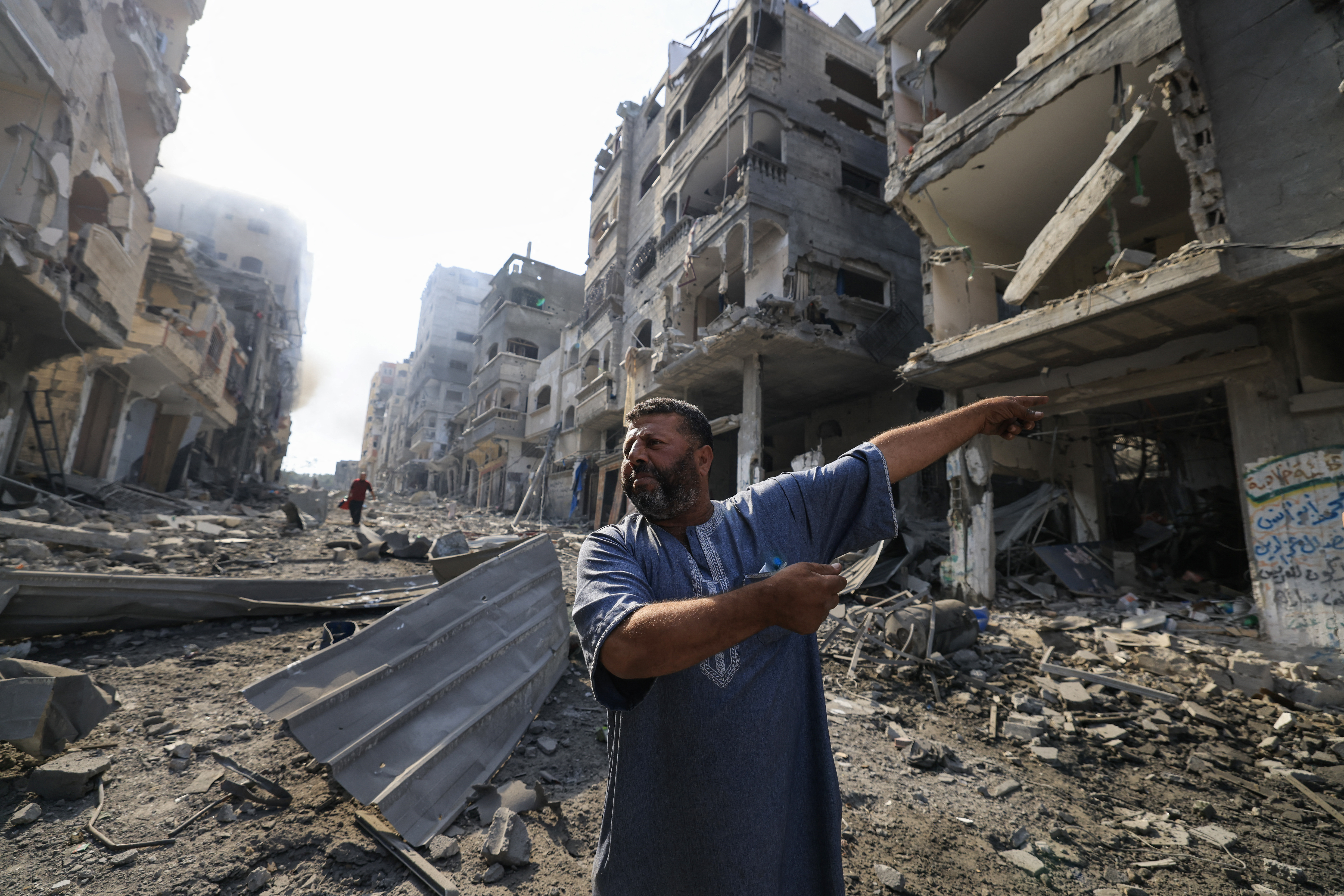 A distraught Palestinian man points at the destruction following overnight Israeli air raids in the Gaza Strip’s Jabalia refugee camp on October 11, 2023