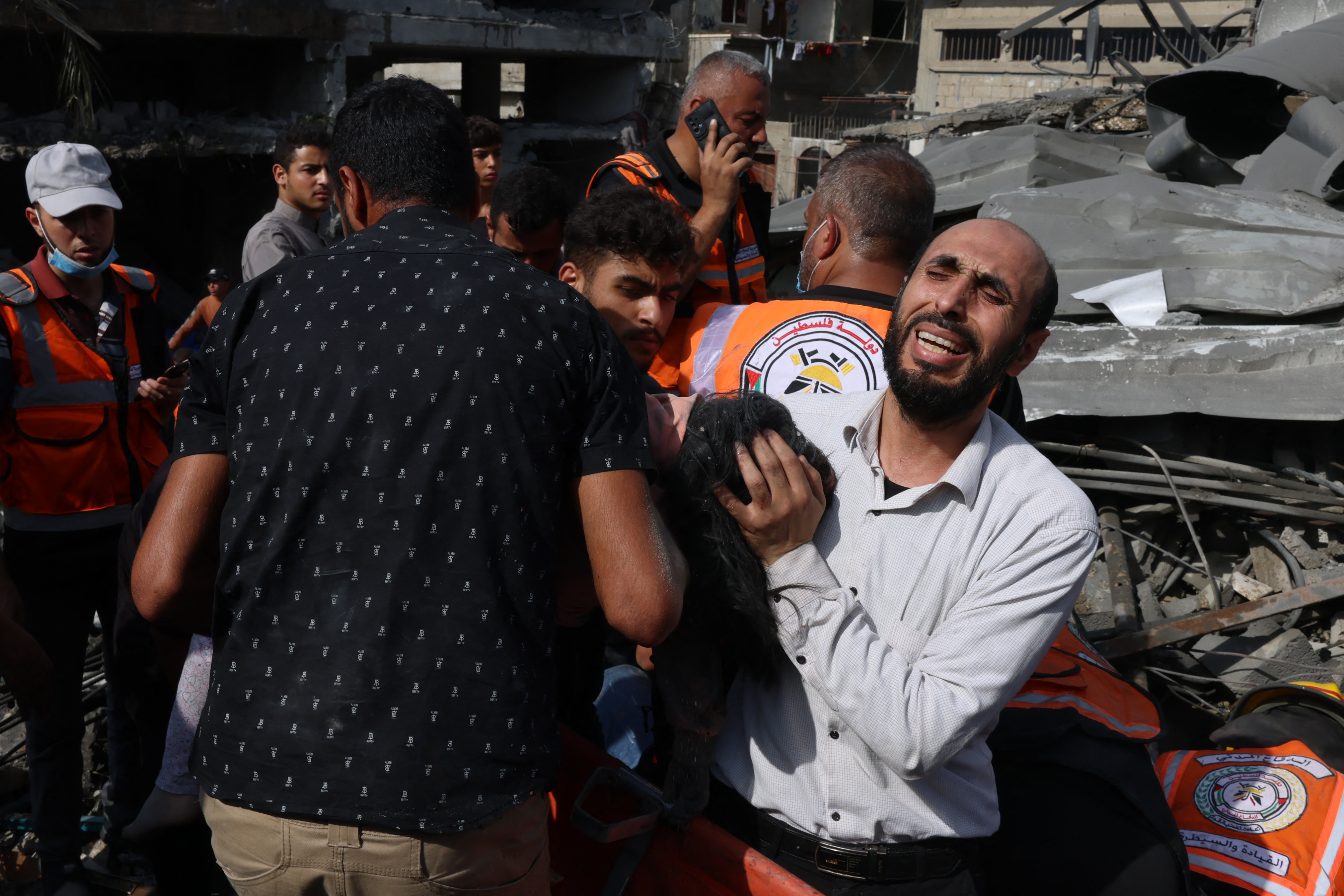 Palestinian man reacts as the body of his daughter is unearthed from under the rubble after an Israeli strike on Rafah
