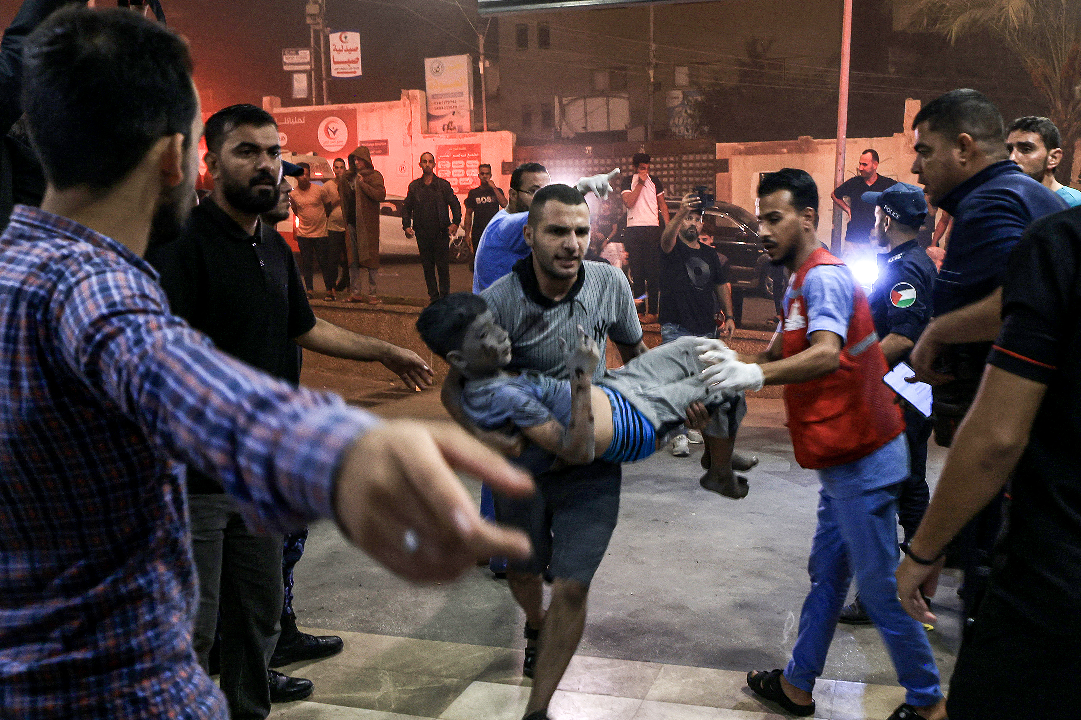 A child who was injured in Israeli bombardment is carried to the entrance for emergency treatment at Nasser Hospital in Khan Younis in the southern Gaza Strip
