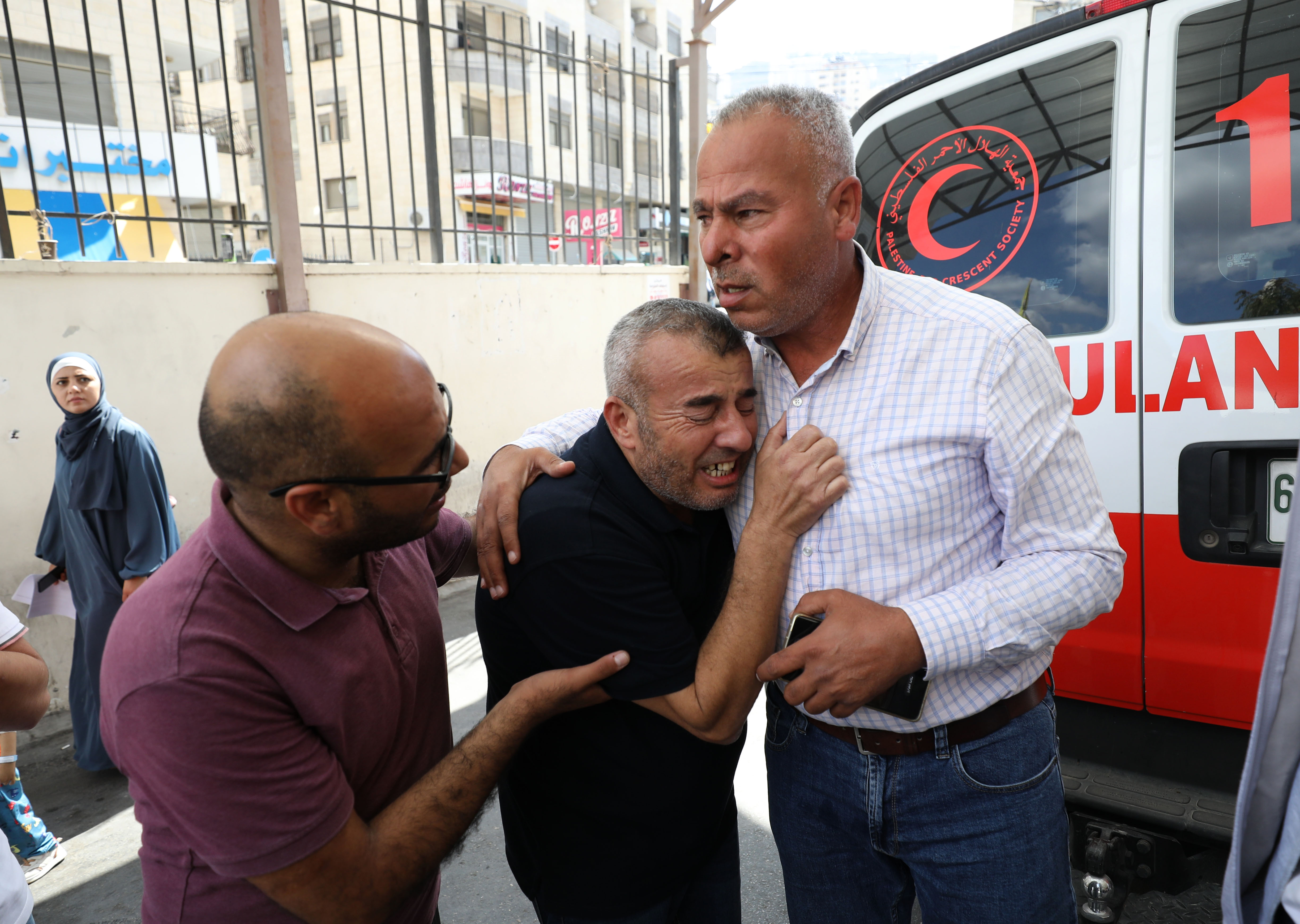 Ibrahim’s family members and friends mourn the killings at a hospital in Nablus