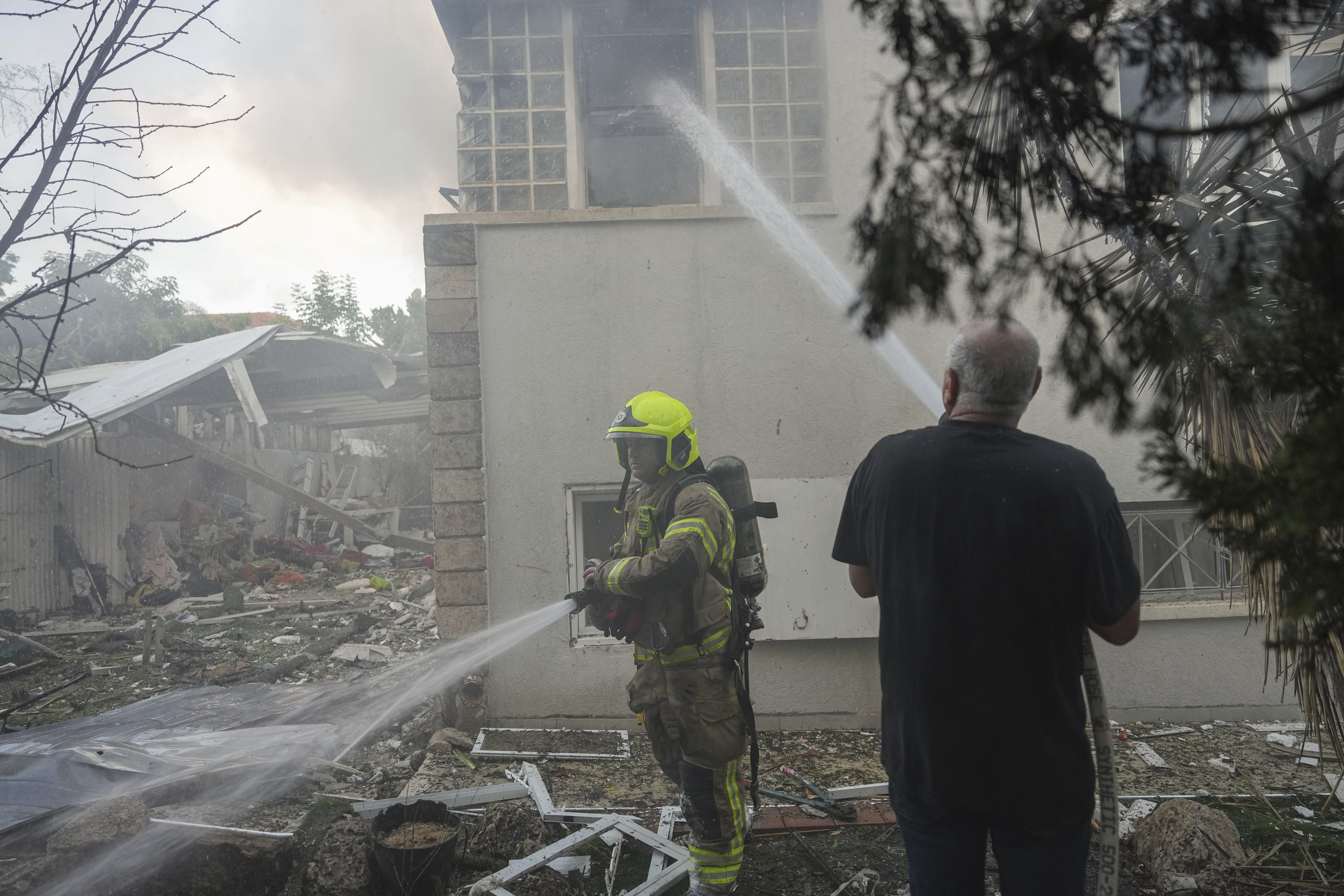 Israeli firefighters extinguish fire after a rocket fired from the Gaza Strip
