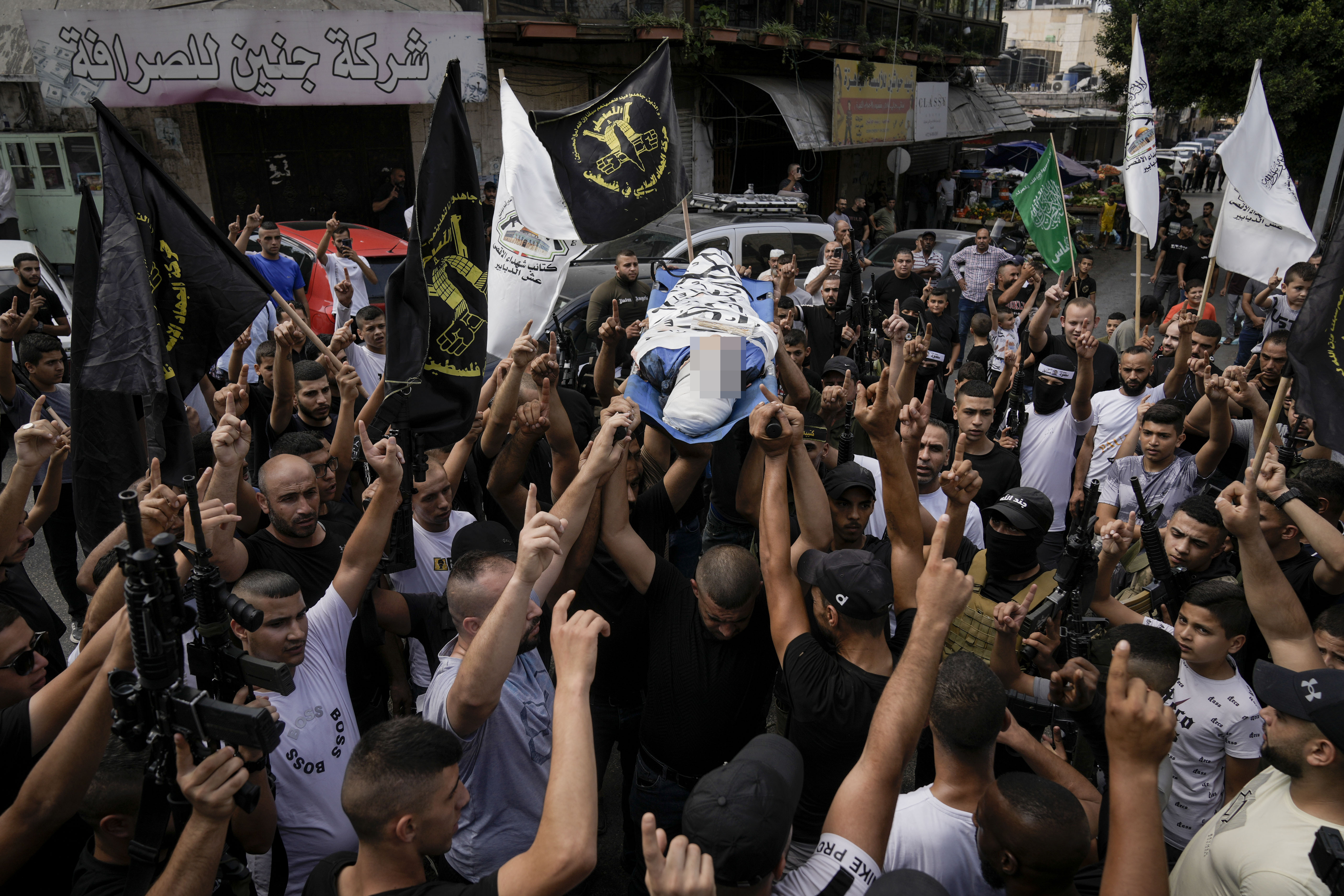 Palestinians carry the body of Ahmad Awawda, 19, who was killed in clashes with Israeli troops near the city of Nablus the previous day, during his funeral in the West Bank city of Jenin, October 8, 2023