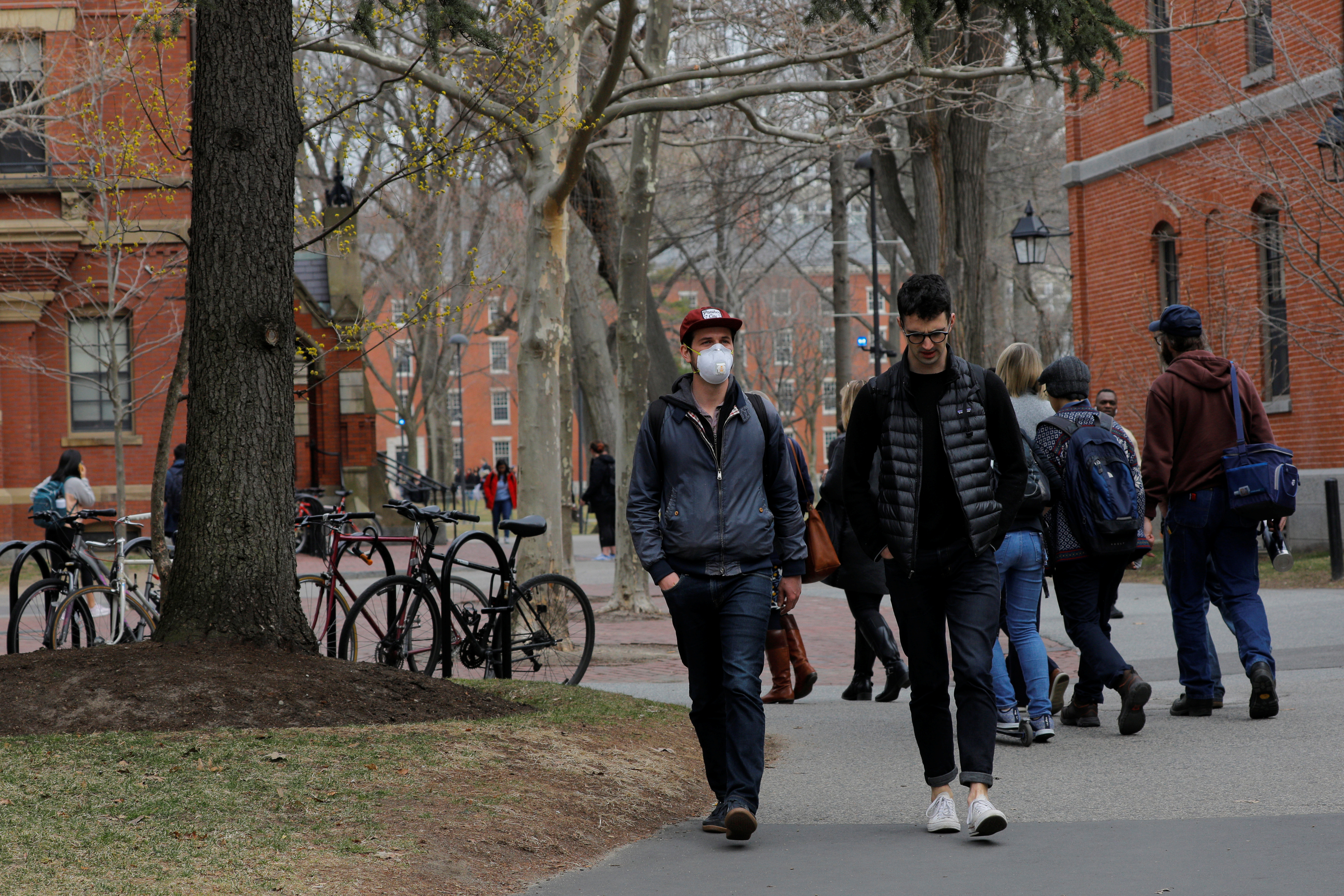 Students walk across the Yard at Harvard University in early March 2020, days before COVID forced the campus to close many of its facilities