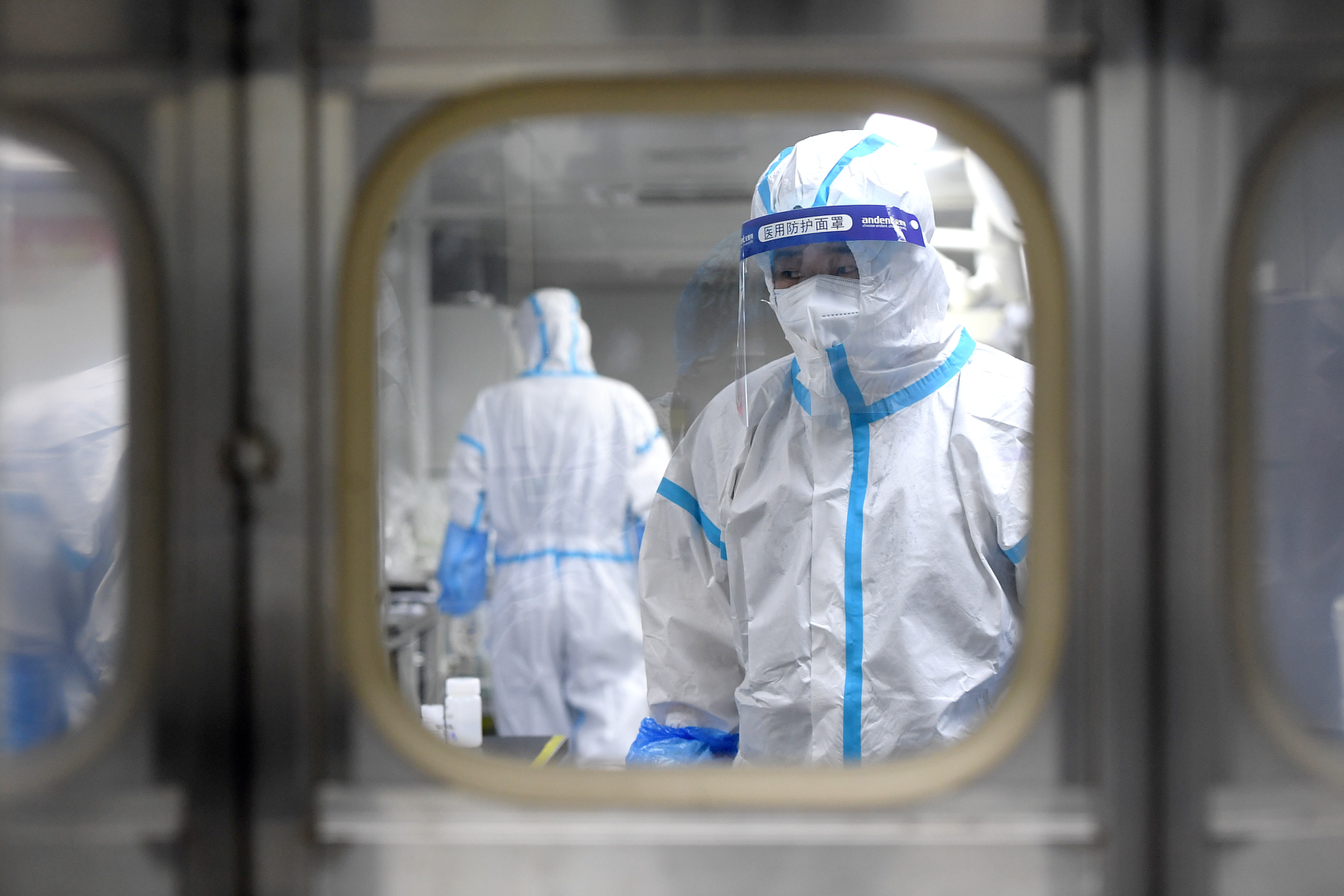 Workers in hazmat suits test samples after a COVID-19 outbreak.