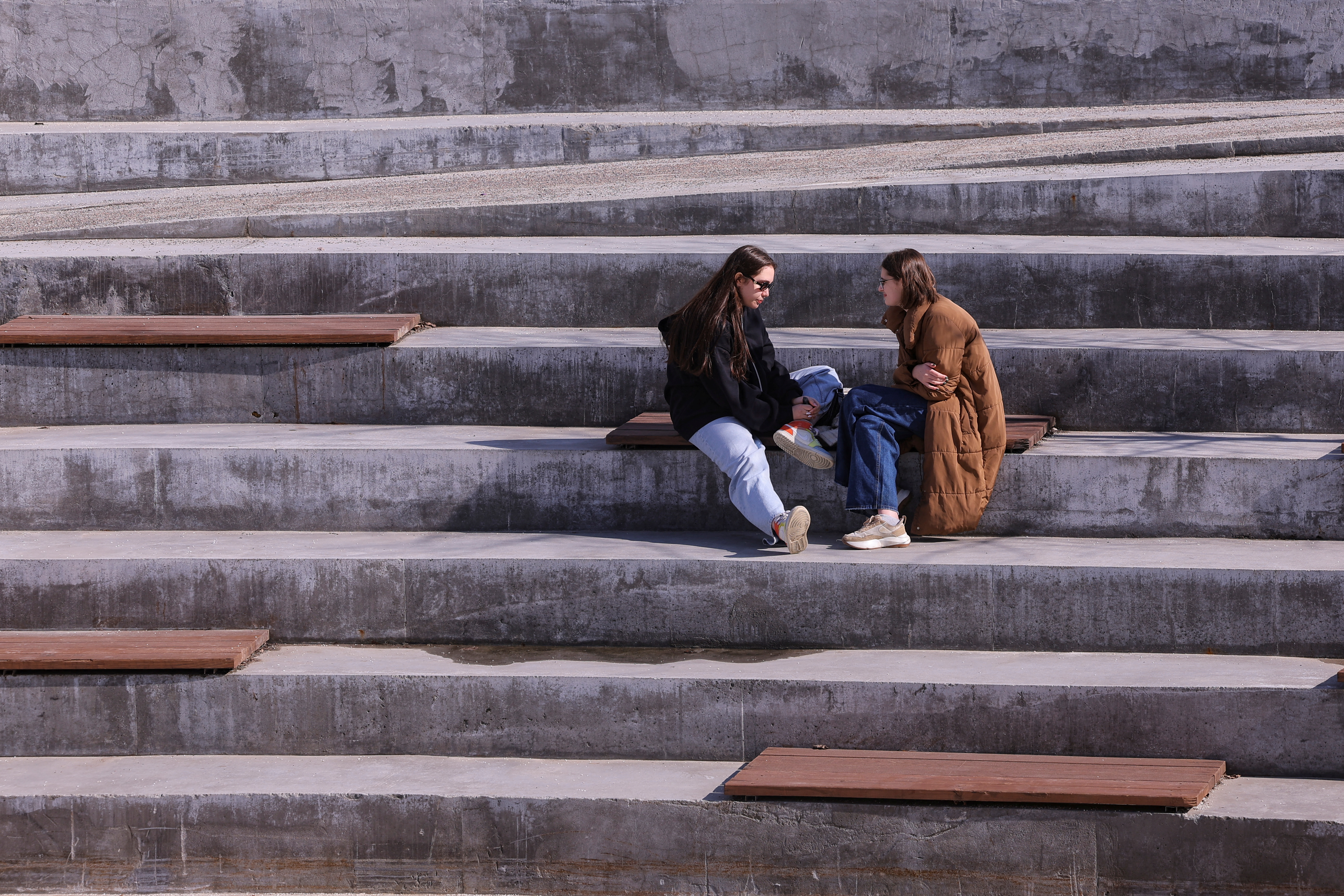 Women rest at a square on a sunny day in Moscow, Russia, March 23, 2023. REUTERS/Evgenia Novozhenina