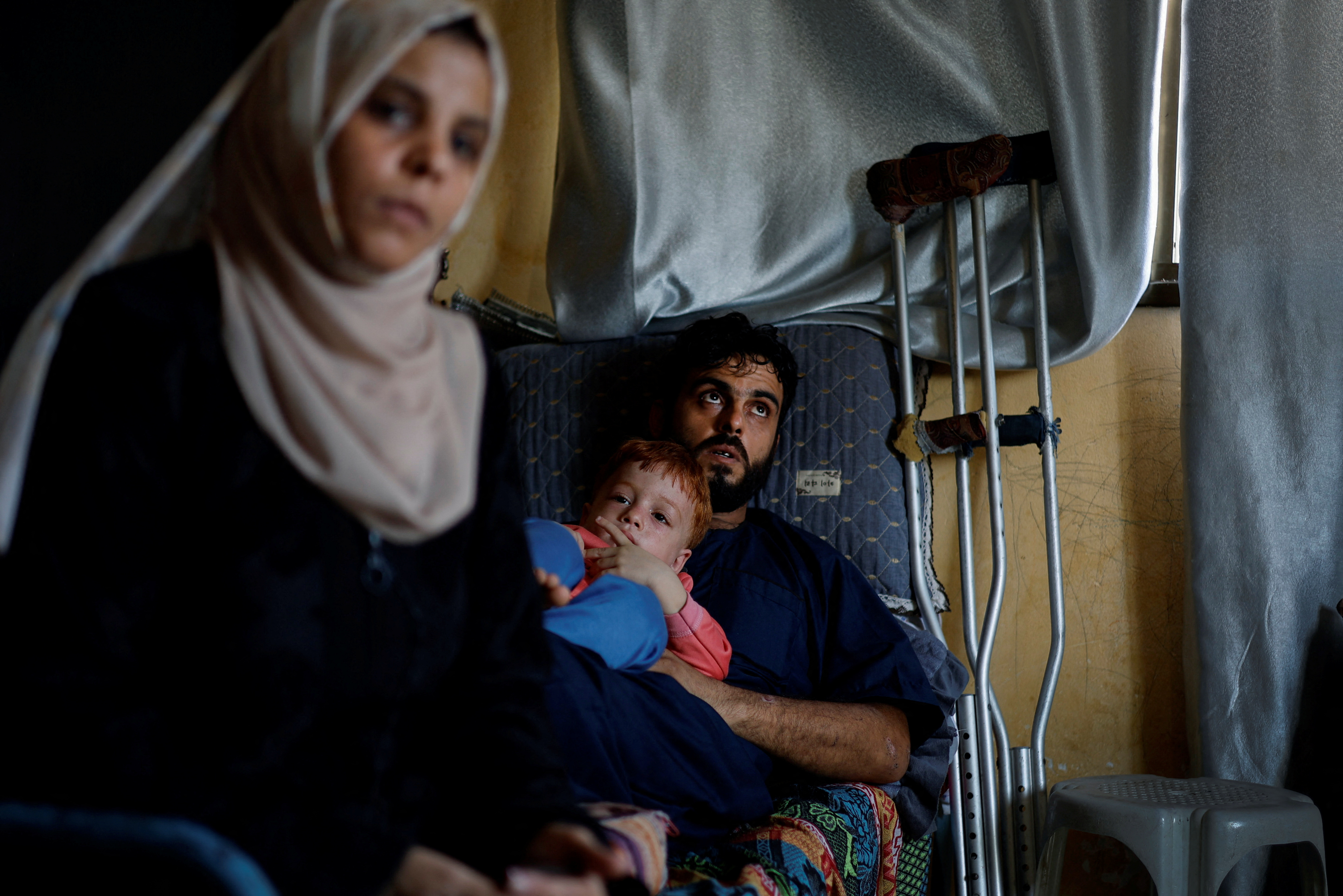 Palestinian woman Inas Abu Maamar, 36, whose picture embracing the body of her 5-year-old niece Saly who was killed in an Israeli air strike went viral on local and international media, sits next to her brother Ramez, the father of Saly, as her nephew Ahmed, 4, looks on, in Khan Younis in the southern Gaza Strip.