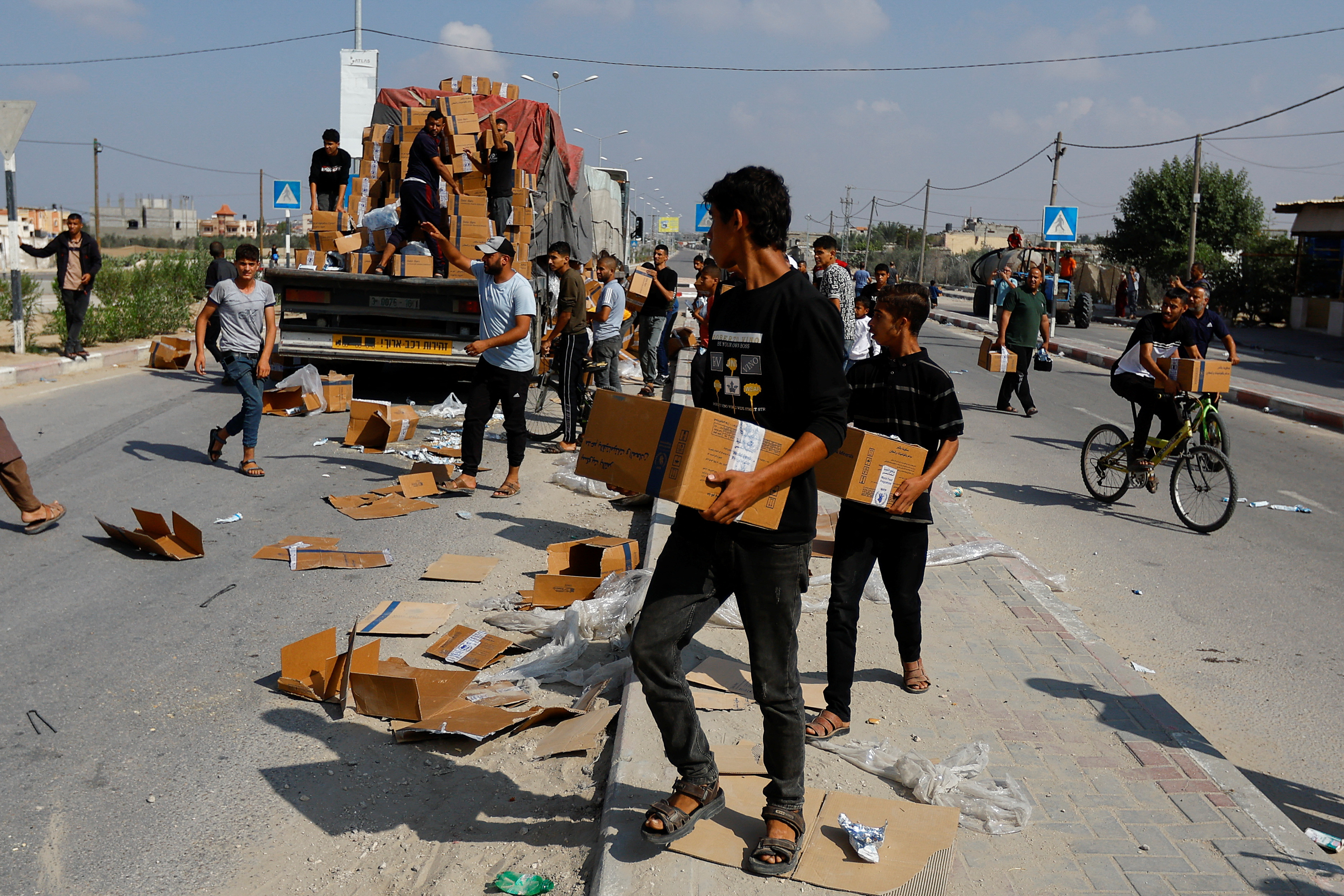 Palestinians carry aid that has fallen from a truck, amid shortages of food supplies in Rafah in the southern Gaza Strip, November 2, 2023