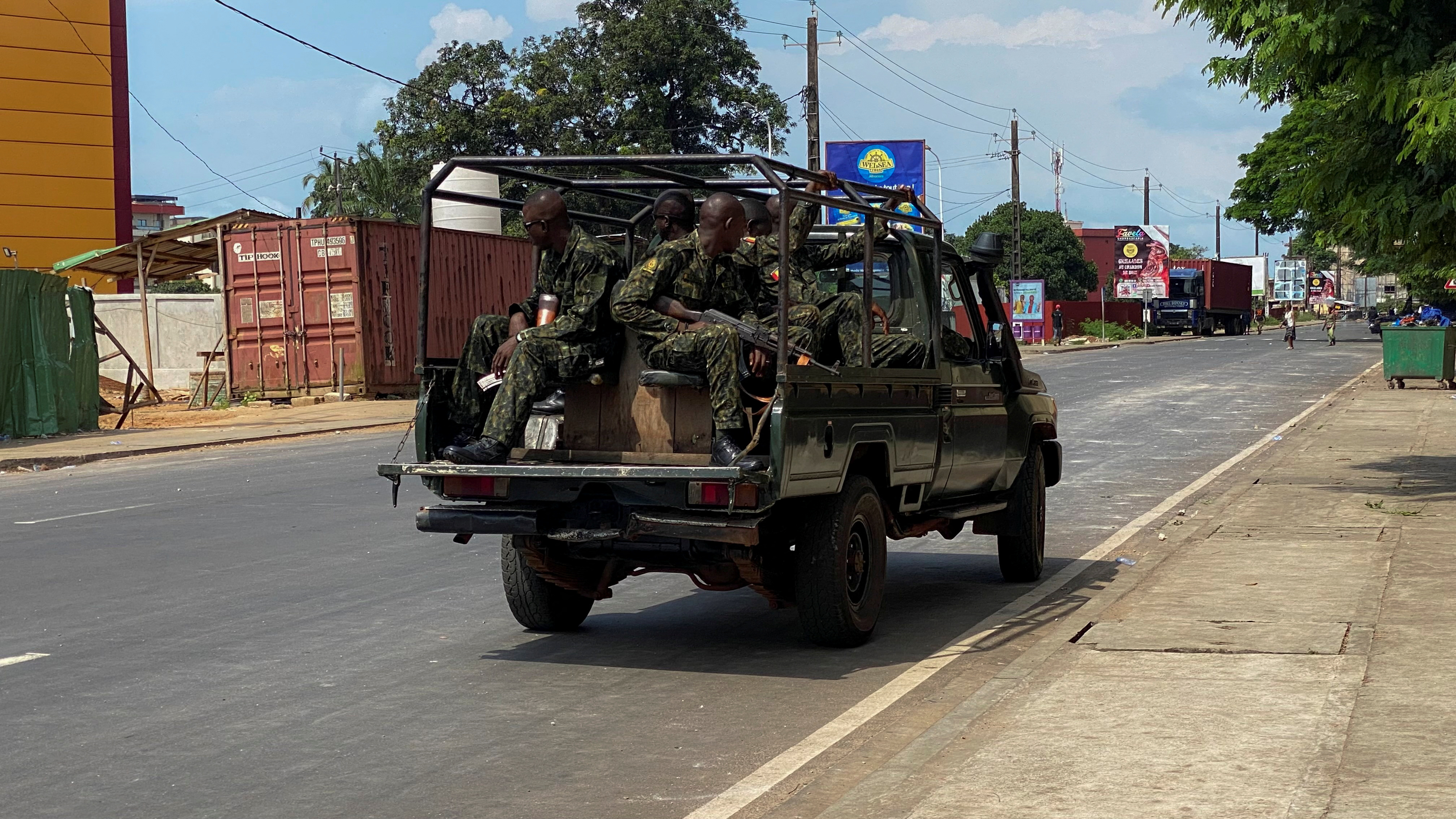 A convoy of Guinean security forces patrol a street