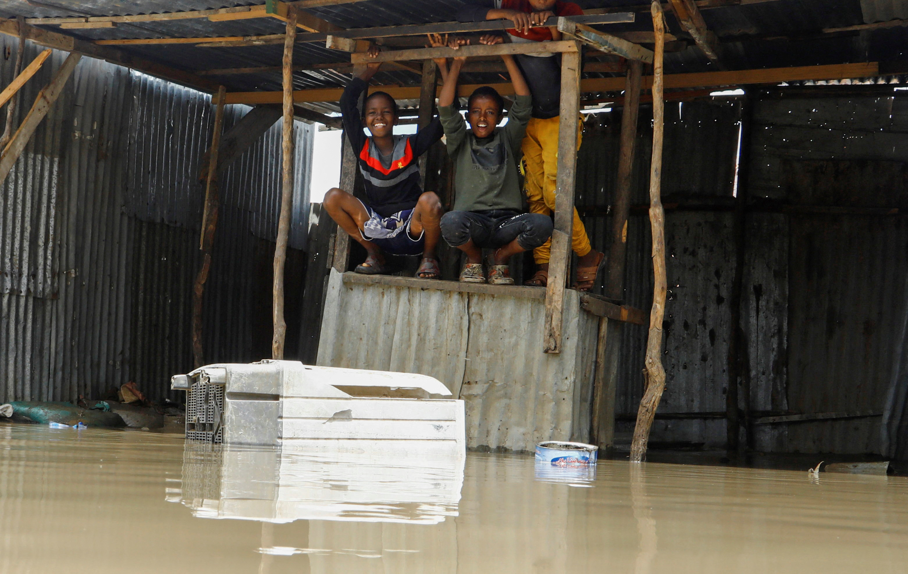 Somali boys play on a flooded kiosk stands near makeshift shelters destroyed following heavy rains at the Al Hidaya camp for the internally displaced people on the outskirts of Mogadishu, Somalia November 6, 2023