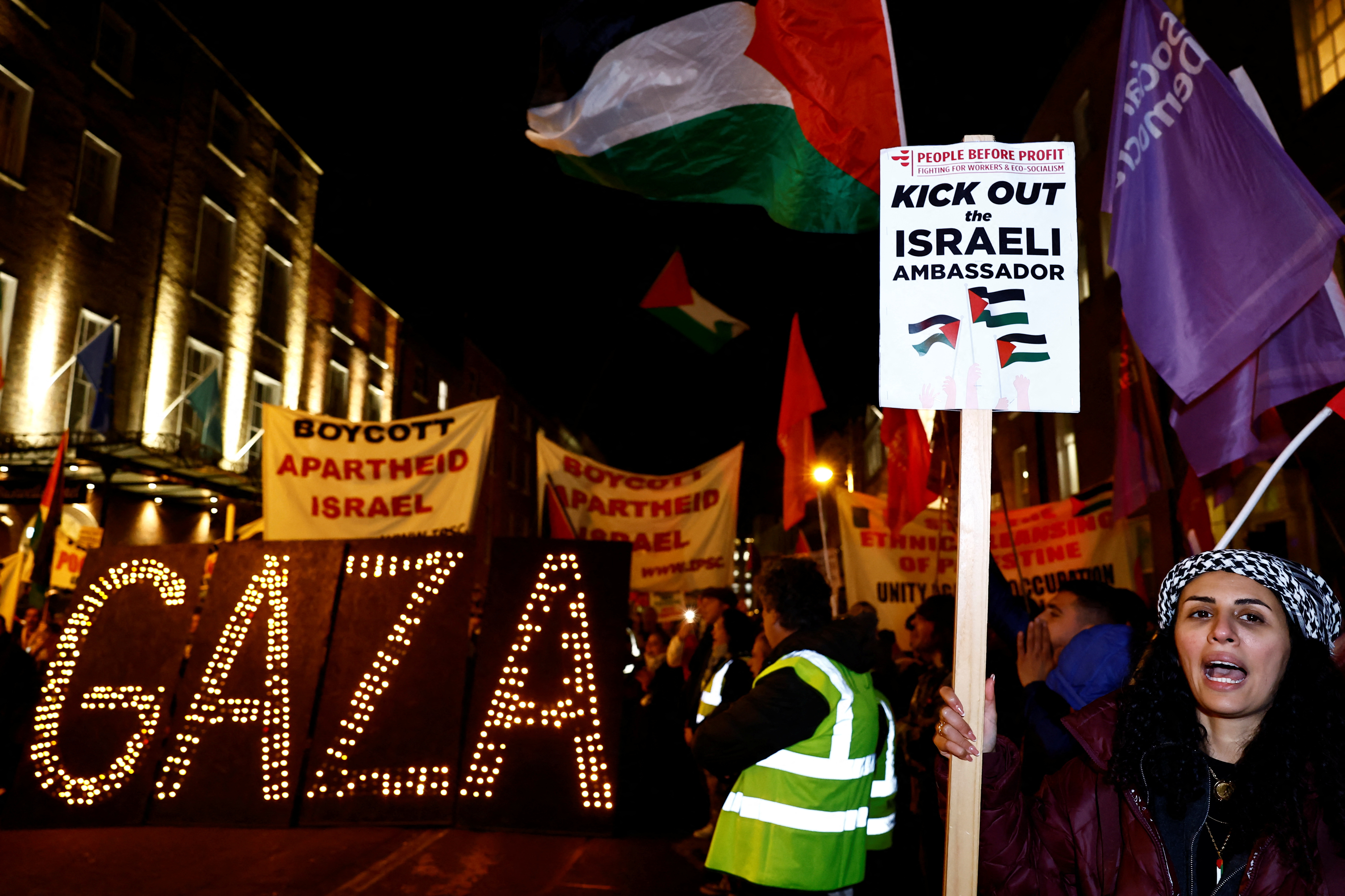 A woman holds a sign as people take part in a protest related to a government vote to expel the Israeli Ambassador to Ireland Dana Erlich, in solidarity with Palestinians in Gaza, in Dublin, Ireland, November 15, 2023 [Clodagh Kilcoyne/Reuters]