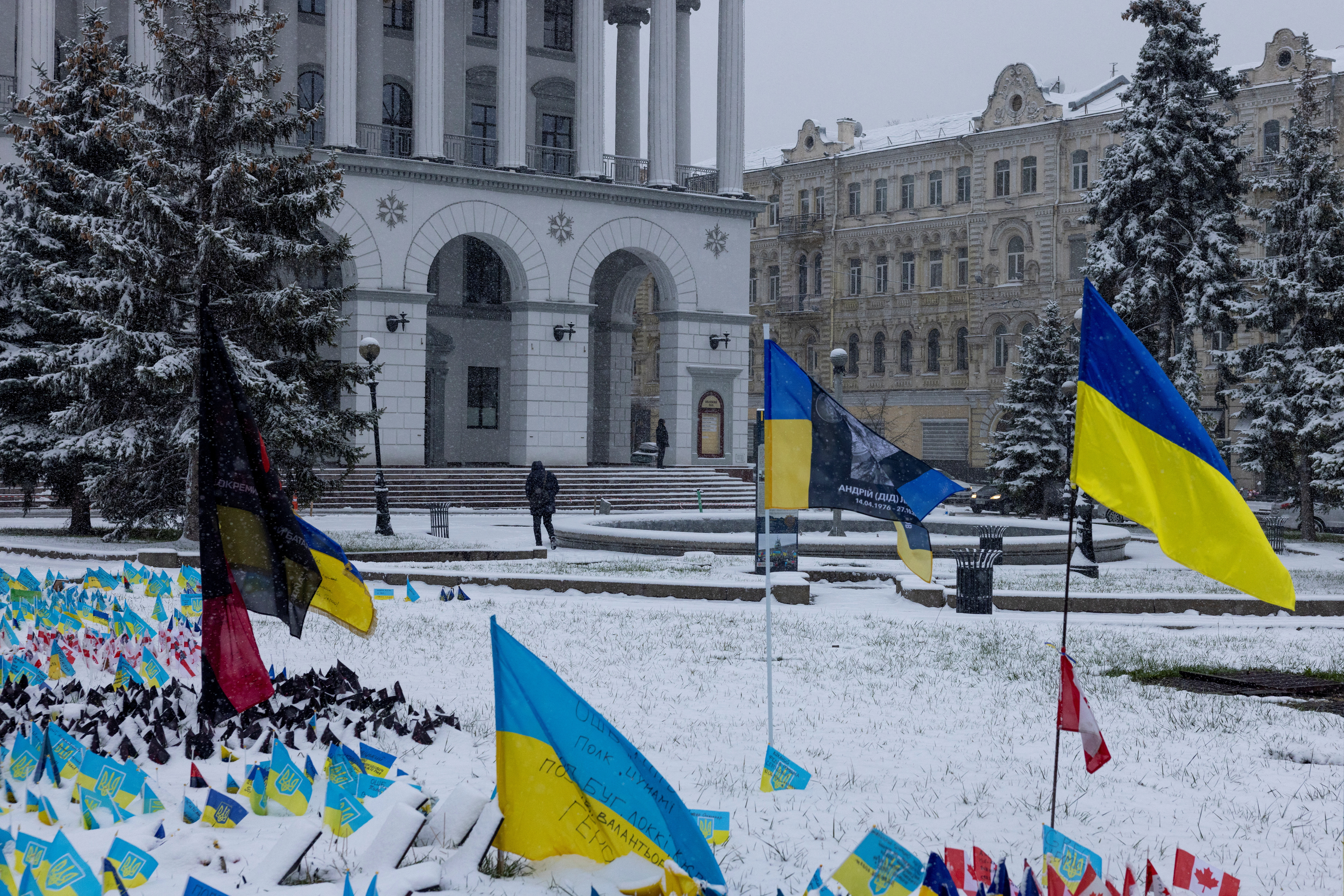 A man walks near a memorial site for servicemen who lost their lives fighting against the Russian attack on Ukraine, in Independence Square on the first snowy day of the year in Kyiv, Ukraine November 22, 2023. REUTERS/Thomas Peter