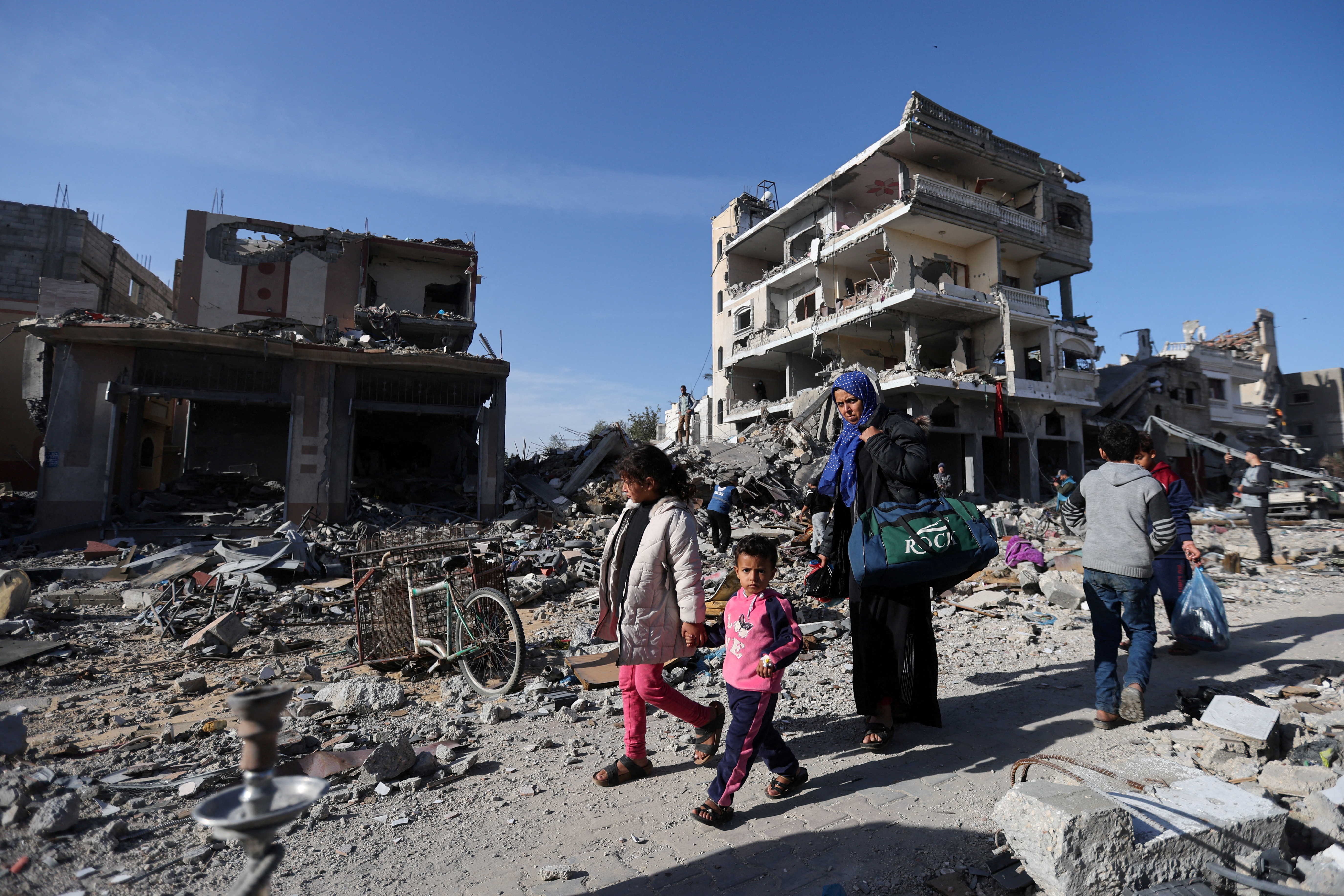 Displaced family in Gaza walks back to its destroyed home