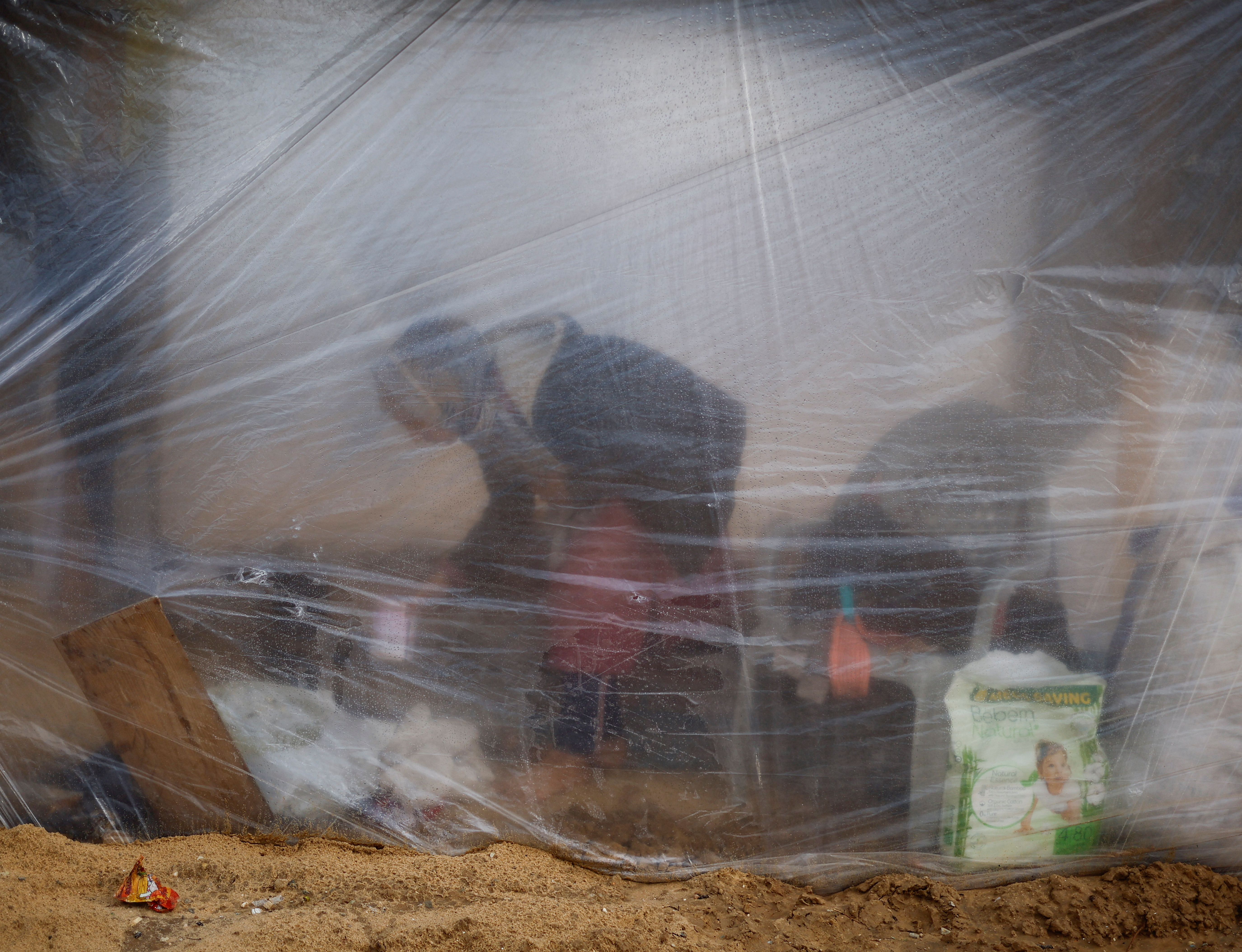 A displaced Palestinian woman inside her flimsy tent in Rafah