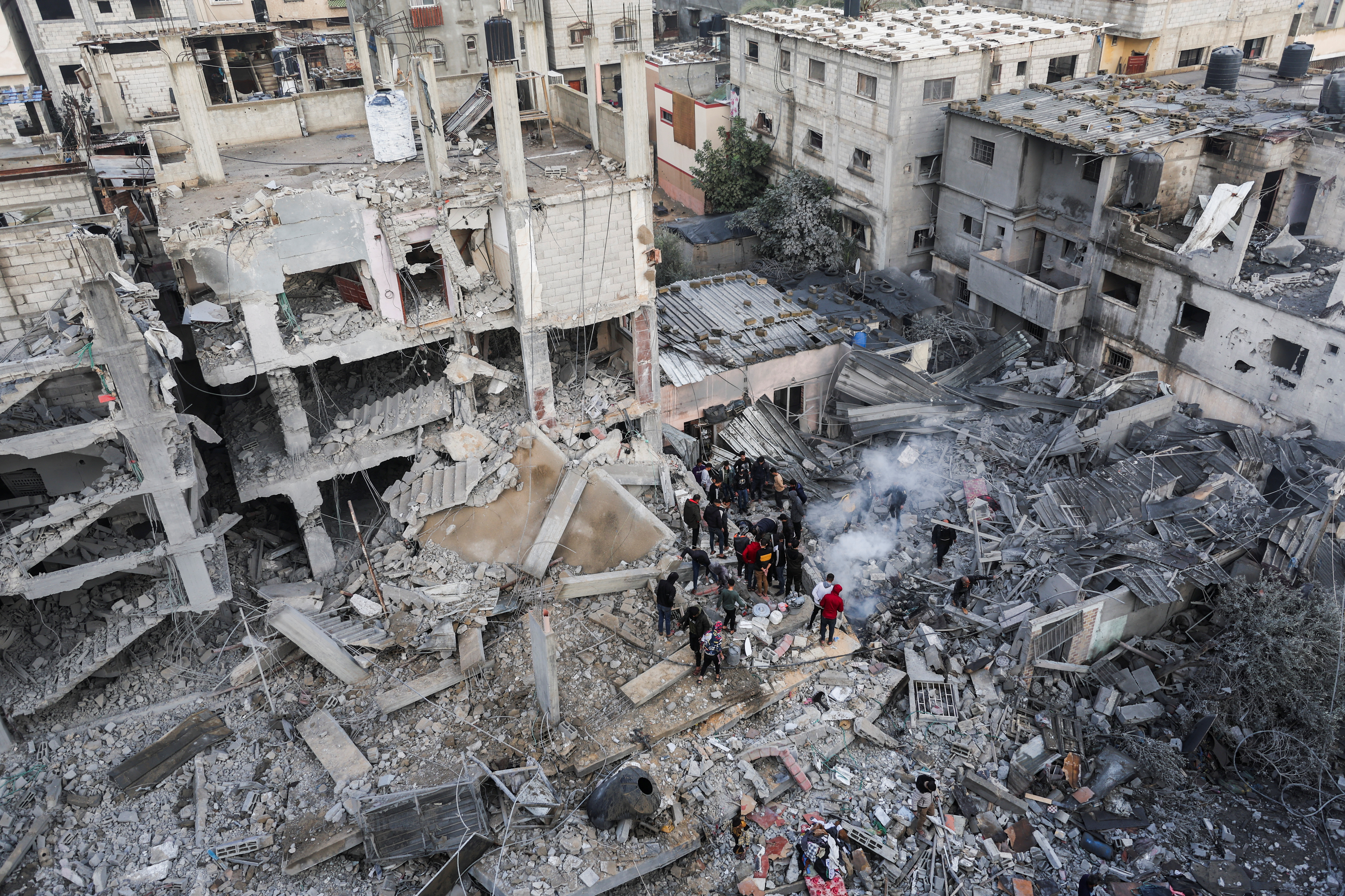 Palestinians gather as smoke rises at the site of Israeli strikes on houses in Khan Younis, in the southern Gaza Strip December 14, 2023. REUTERS/Ibraheem Abu Mustafa