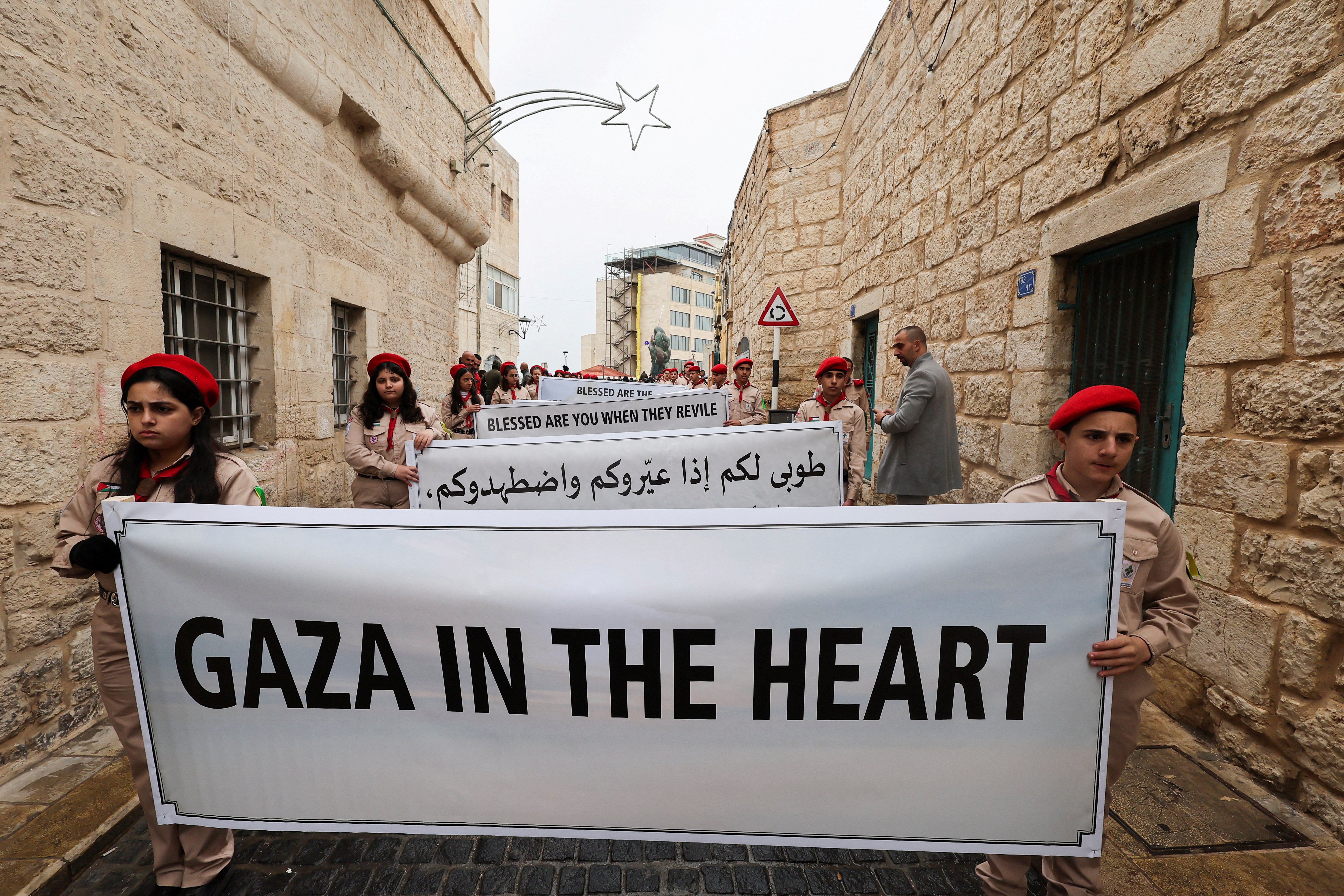 Scouts hold a sign in solidarity with Palestinians in Gaza, on the day of a visit by the Latin Patriarch of Jerusalem, Pierbattista Pizzaballa, to the Old City of Bethlehem