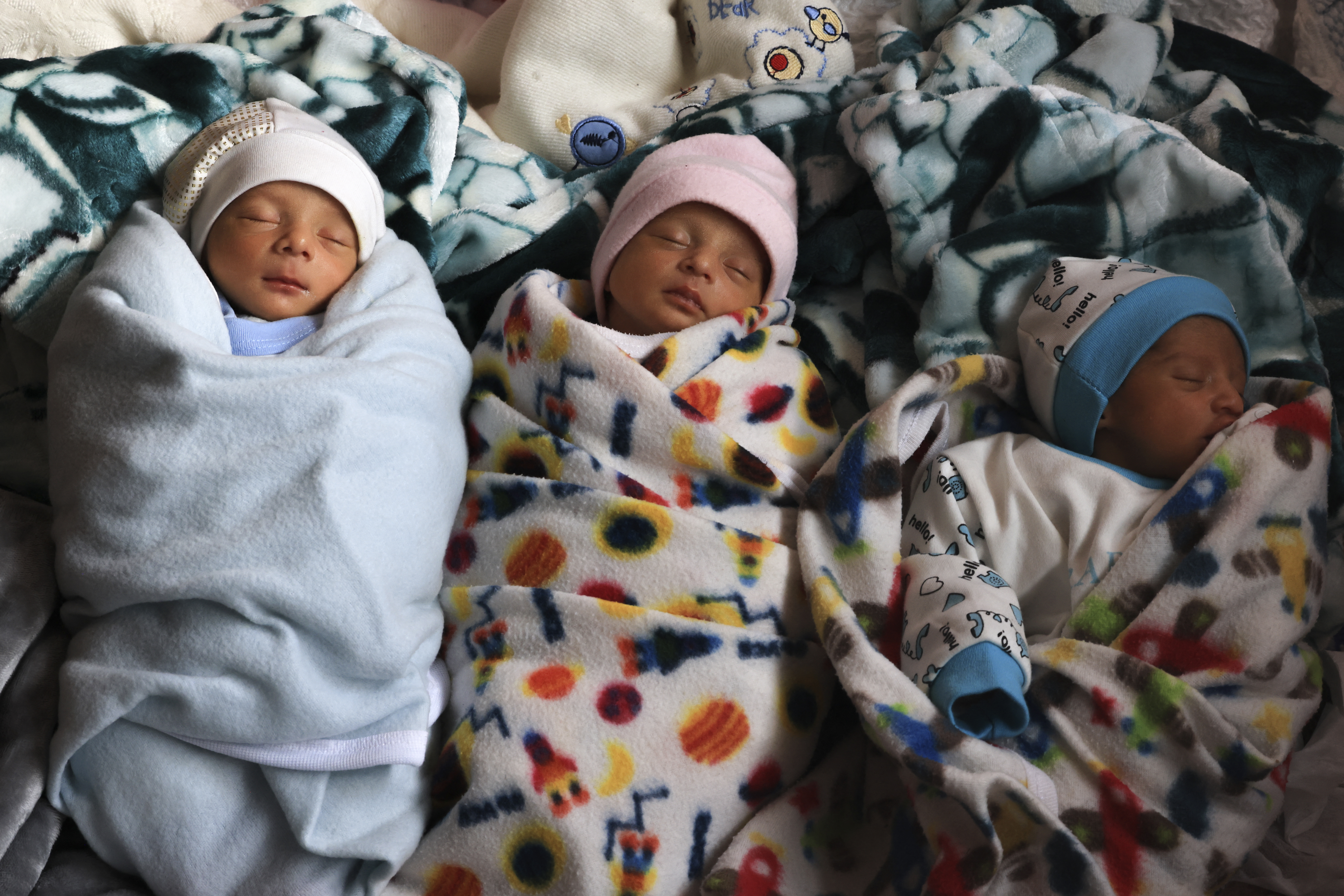 Three of the al-Masry quadruplets – the fourth still being treated in hospital – belonging to Ammar and Iman al-Masry sleep as they shelter at a school in Deir el-Balah in the central Gaza Strip on December 27