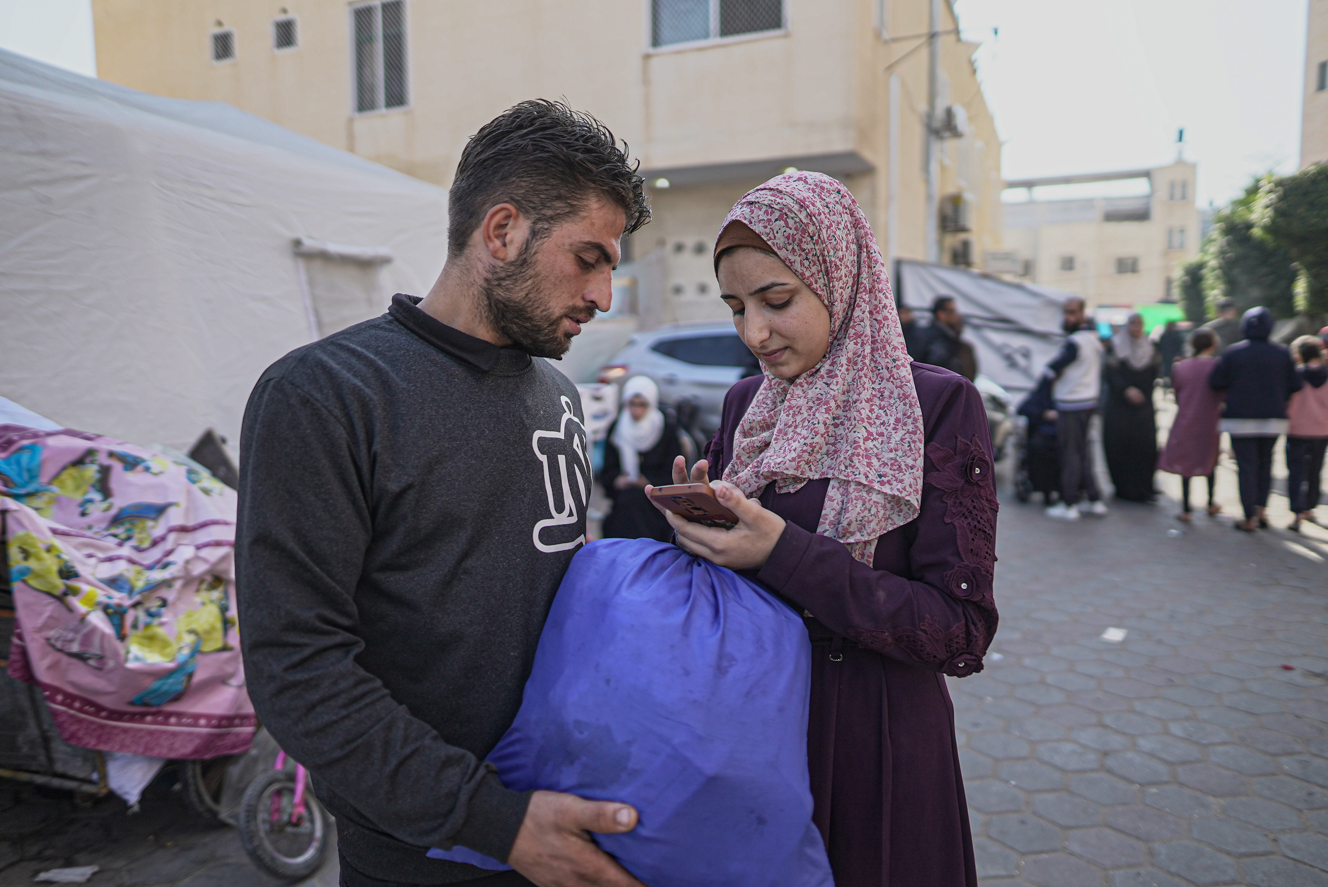 Noor Reyhan and her husband Huthaifa Marouf look at a photo of their baby boy, who Noor hasn't seen for two months [