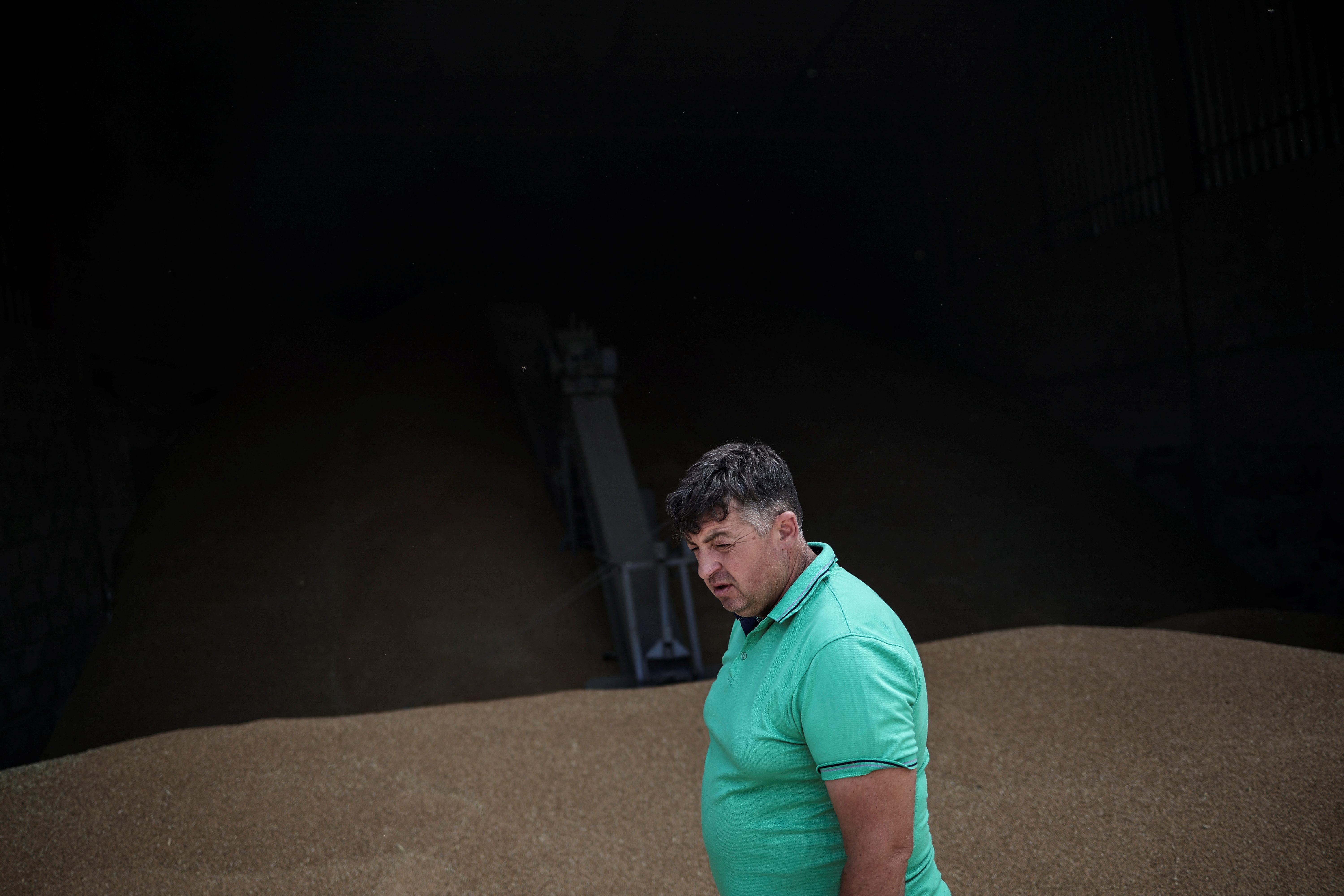 Farmer Vitalii Kistrytsya, 45, walks next to grain at his grain storage facility, as Russia's attack on Ukraine continues, in Dnipropetrovsk region, Ukraine, July 30, 2022. REUTERS/Alkis Konstantinidis