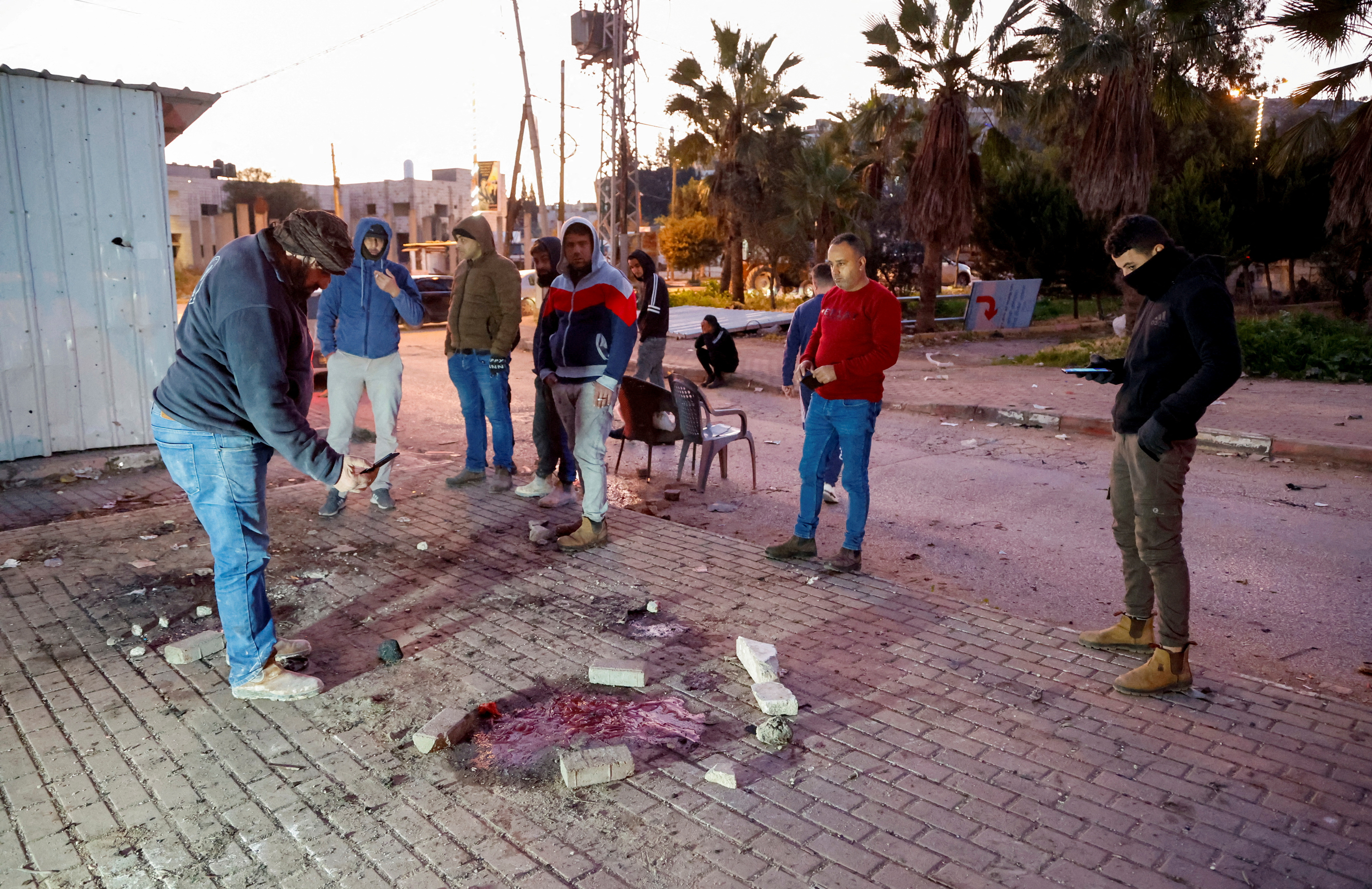 People check the site where Palestinian authorities said an Israeli air raid killed six men, near Jenin in the Israeli-occupied West Bank