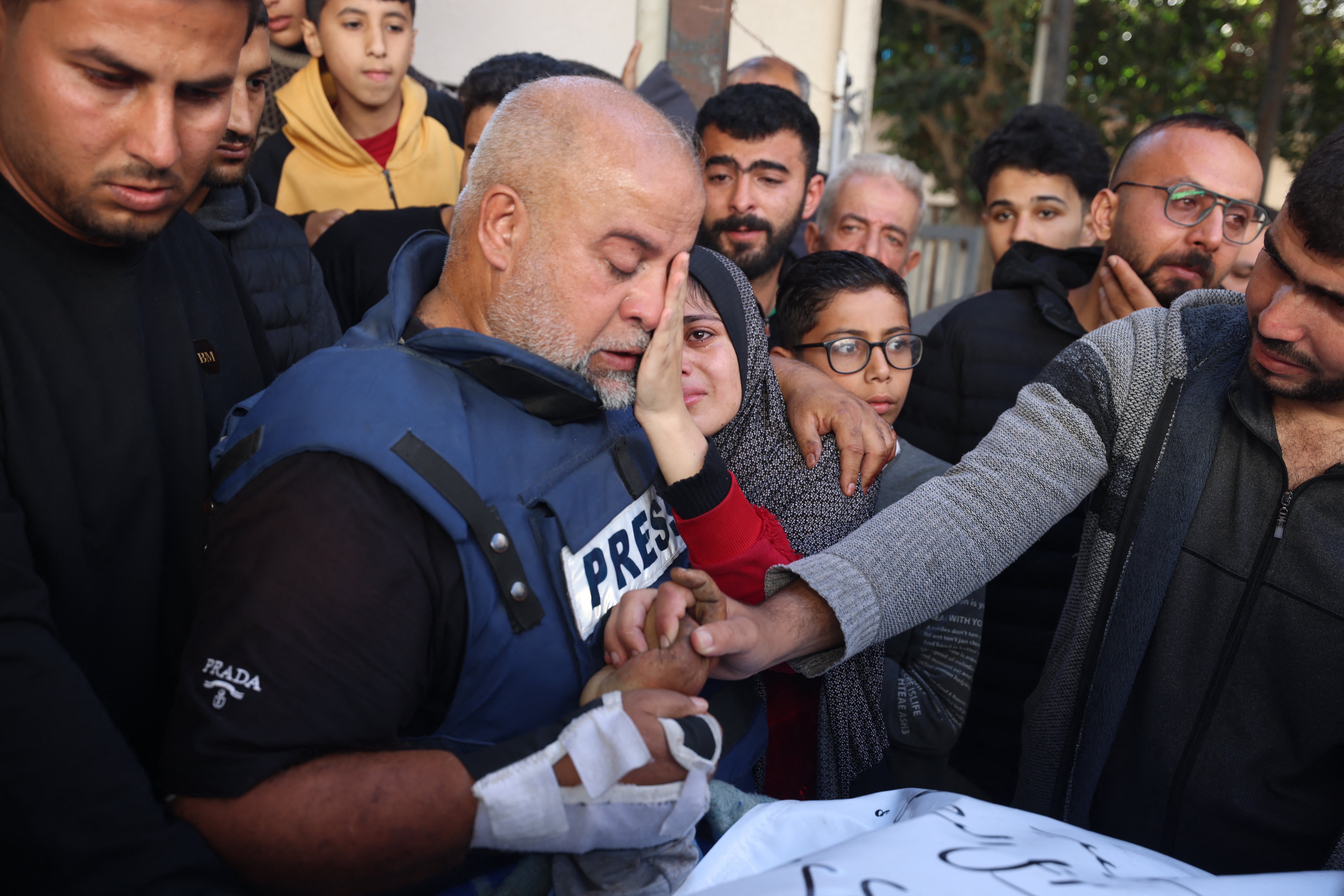 Al Jazeera's bureau chief in Gaza, Wael Al-Dahdouh (C) hugs his daughter during the funeral of his son Hamza Wael Dahdouh, a journalist with the Al Jazeera television network, who was killed in a reported Israeli air strike in Rafah in the Gaza Strip on January 7