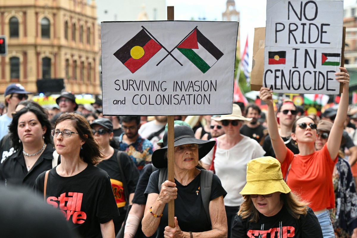 Protesters with signs and placards march during the annual "Invasion Day" protest march through the streets of Sydney