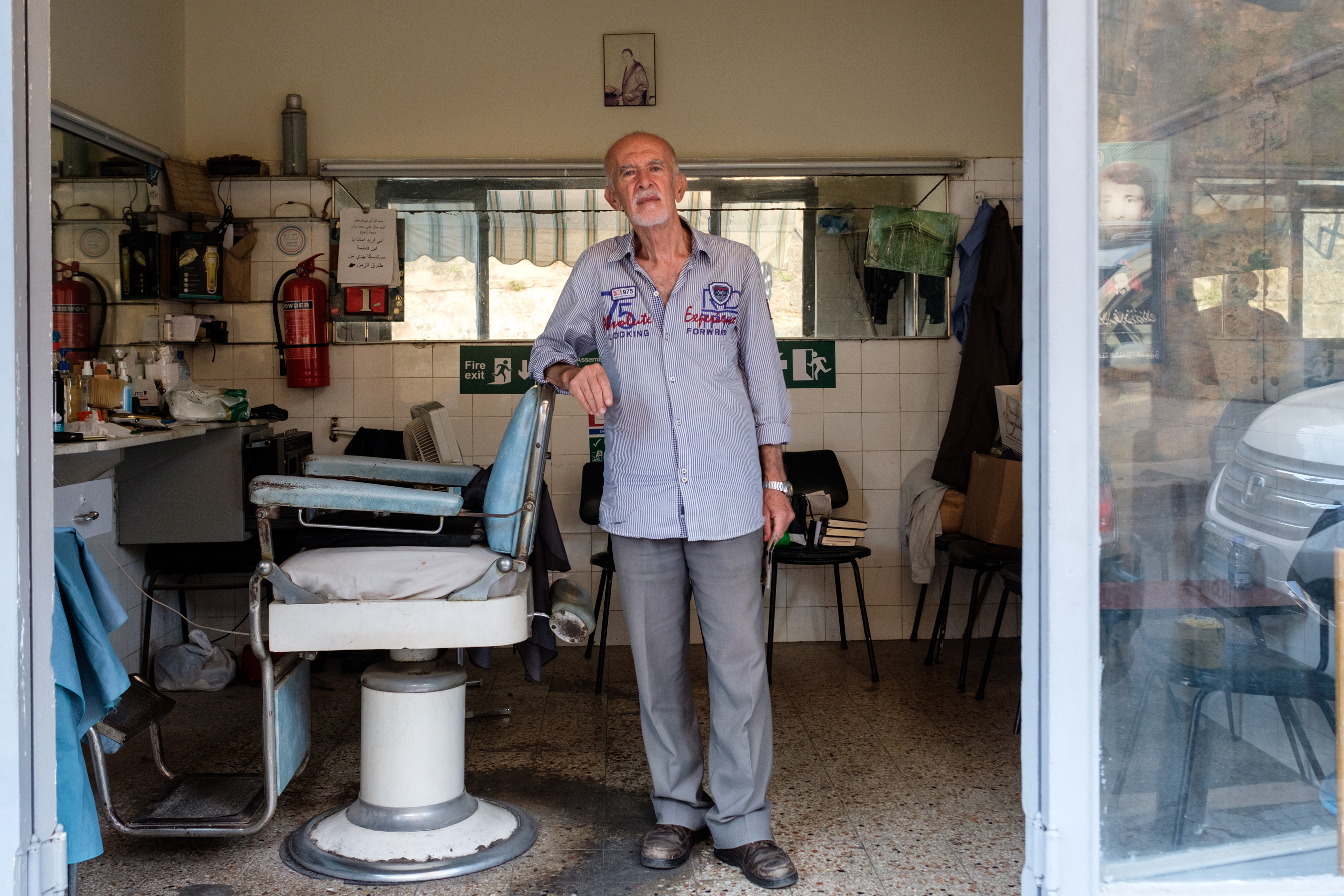 Selman Ali Khreis's father opened this barber shop in el-Khanda el-Ghamee in 1947. He gets about four hours of electricity a day and doesn’t have a backup generator, so he can't stay open very much