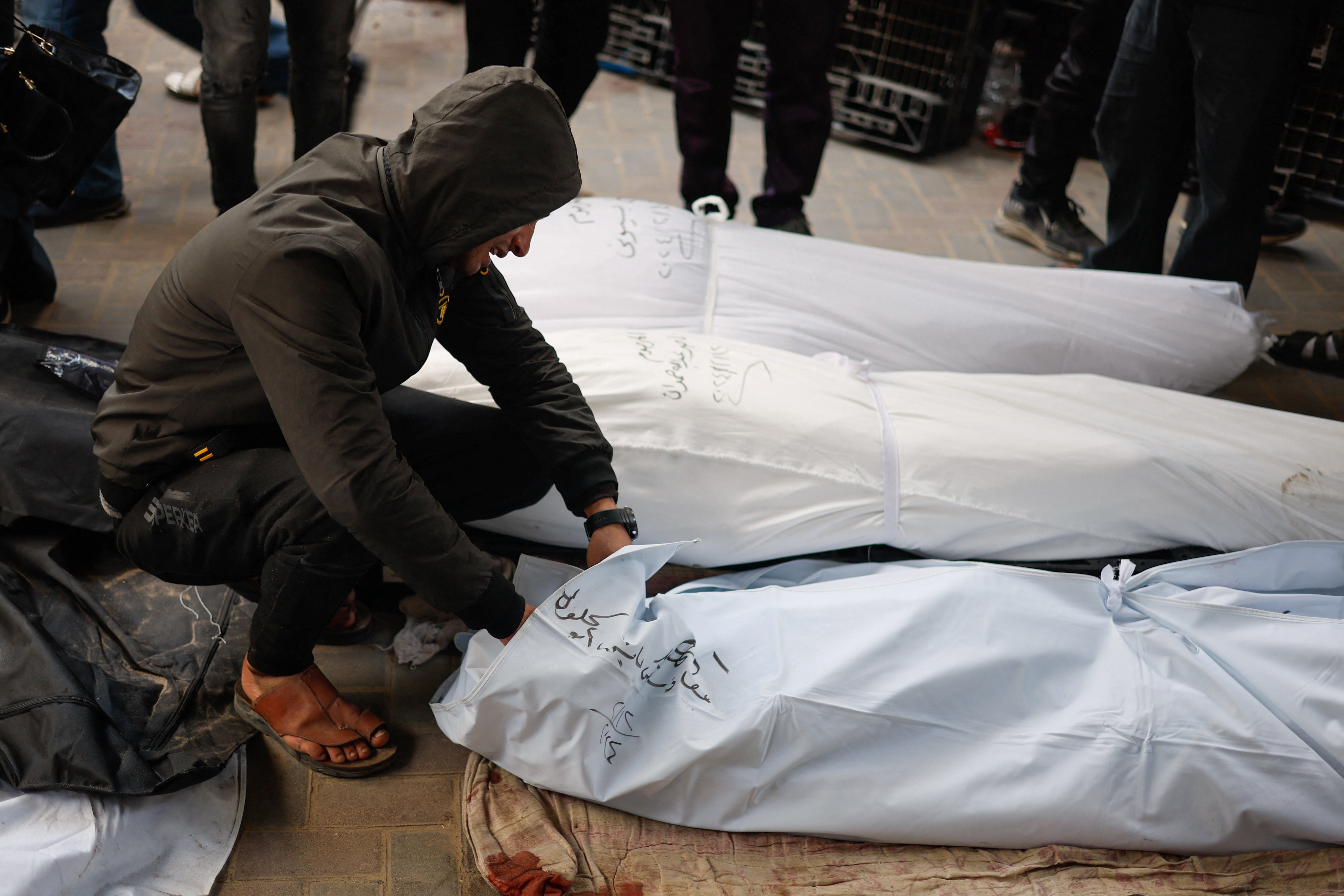 A man reacts next to the bodies of Palestinians killed in Israeli strikes at Abu Yousef Al-Najjar hospital in Rafah on February 12, 2024
