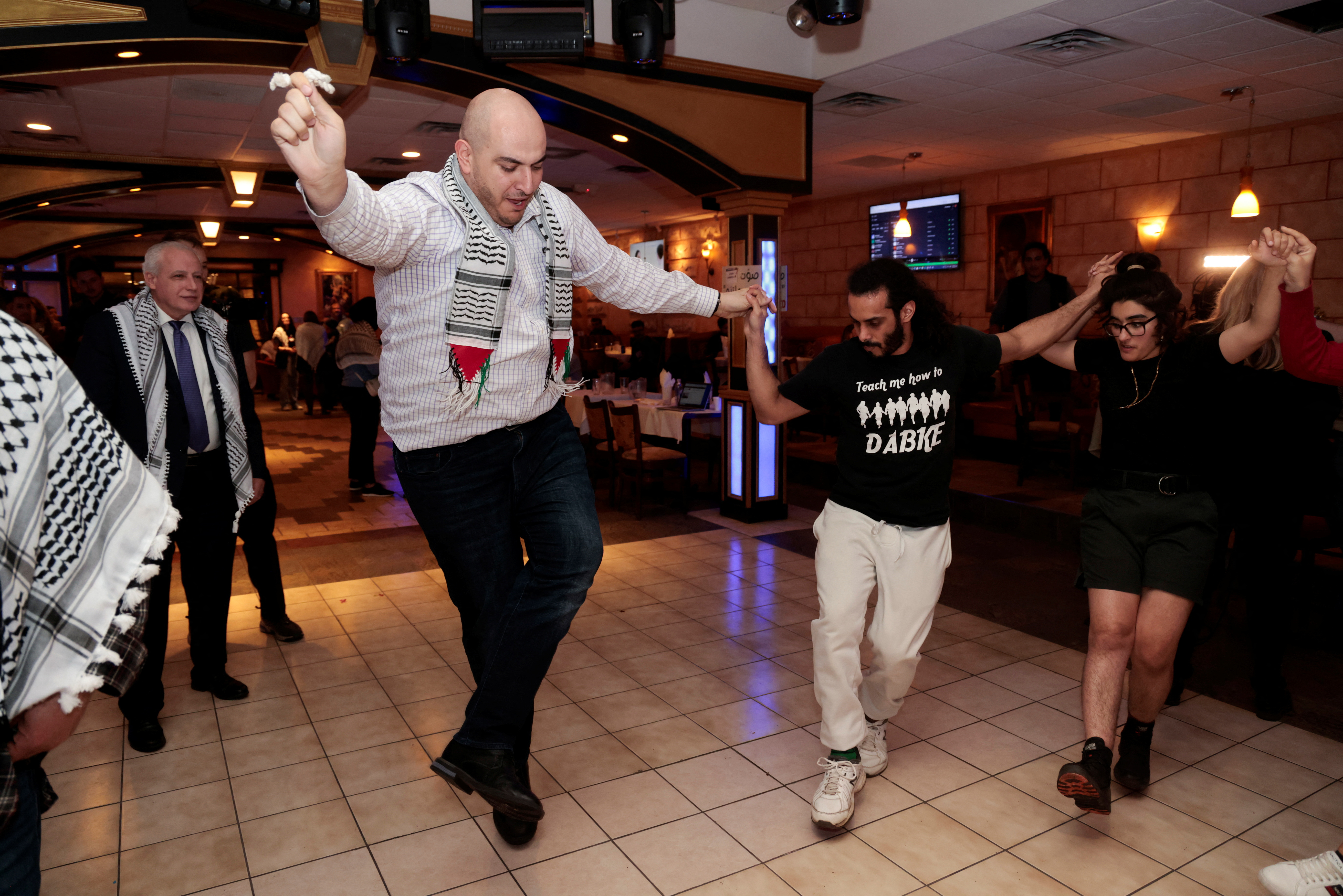 Activist Abbas Alawieh leads a Dabke dance during an ‘uncommitted’ vote election night gathering as Democrats and Republicans hold their Michigan primary presidential election in Dearborn, Michigan