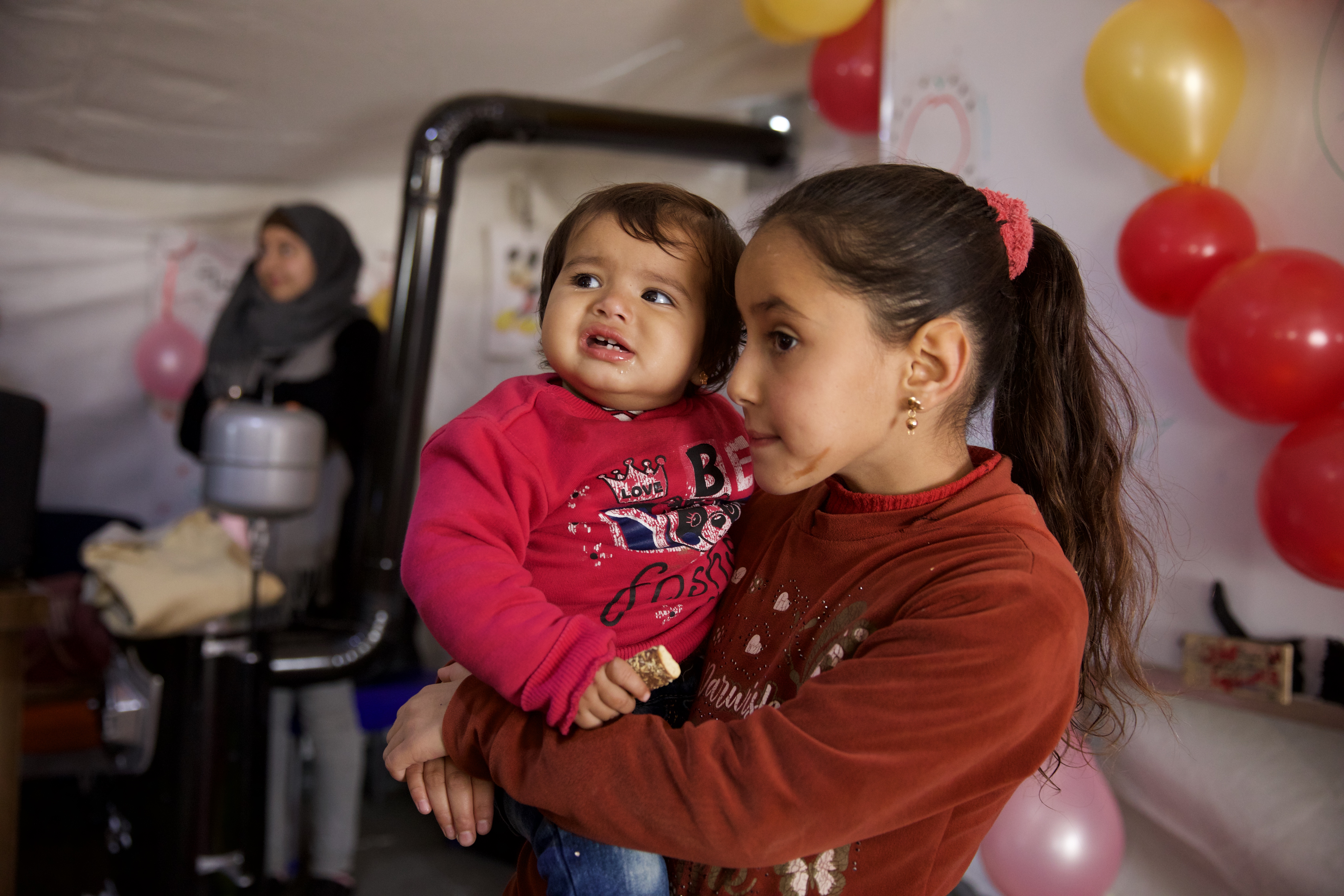 There is an exceptionally strong bond between Afraa and her cousin Doaa, seen here carrying her