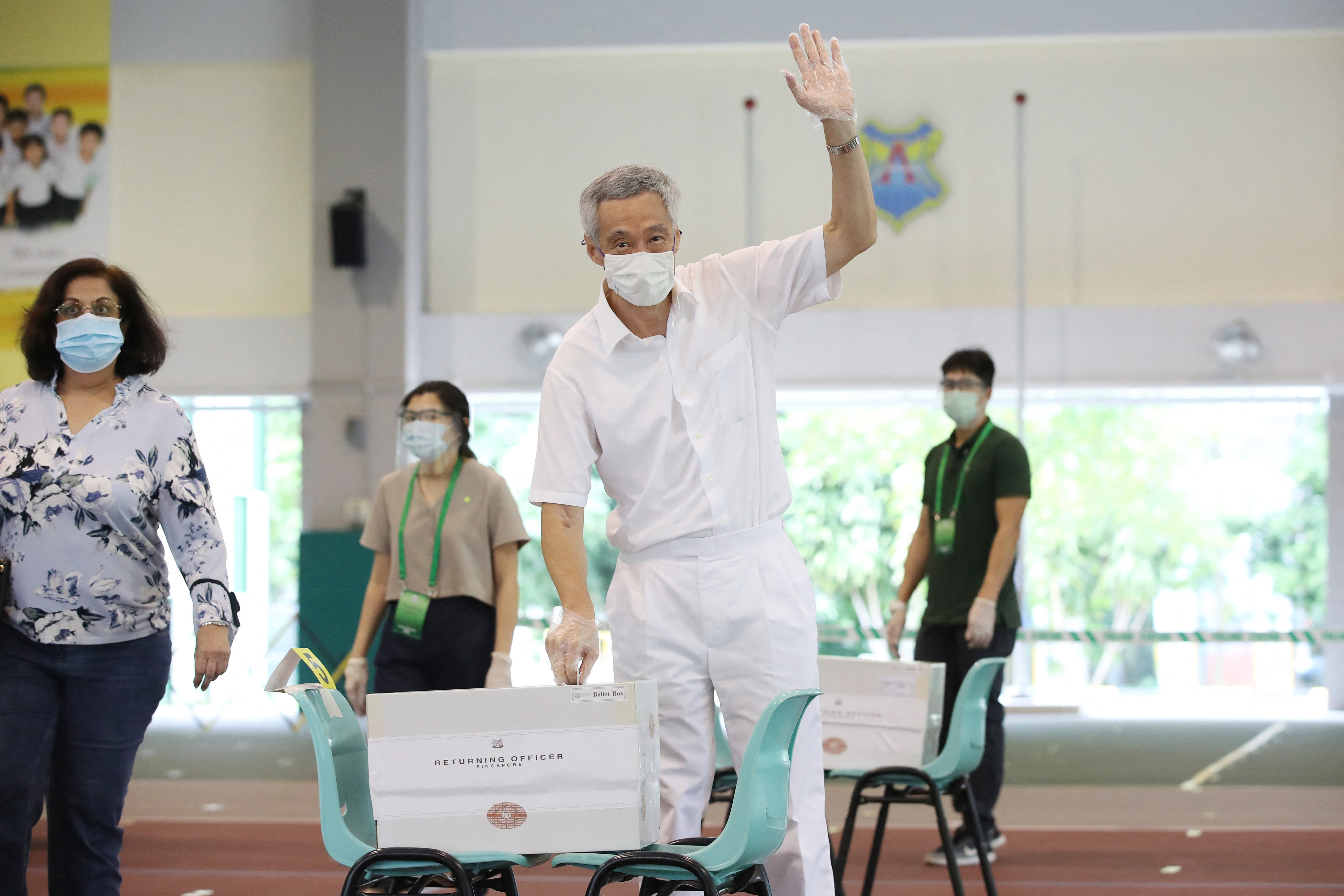 Prime Minister Lee Hsien Loong votes at the last election in 2020 during the COVID-19 pandemic. He has said he plans to step down [Singapore Ministry of Communications and Information via AFP]