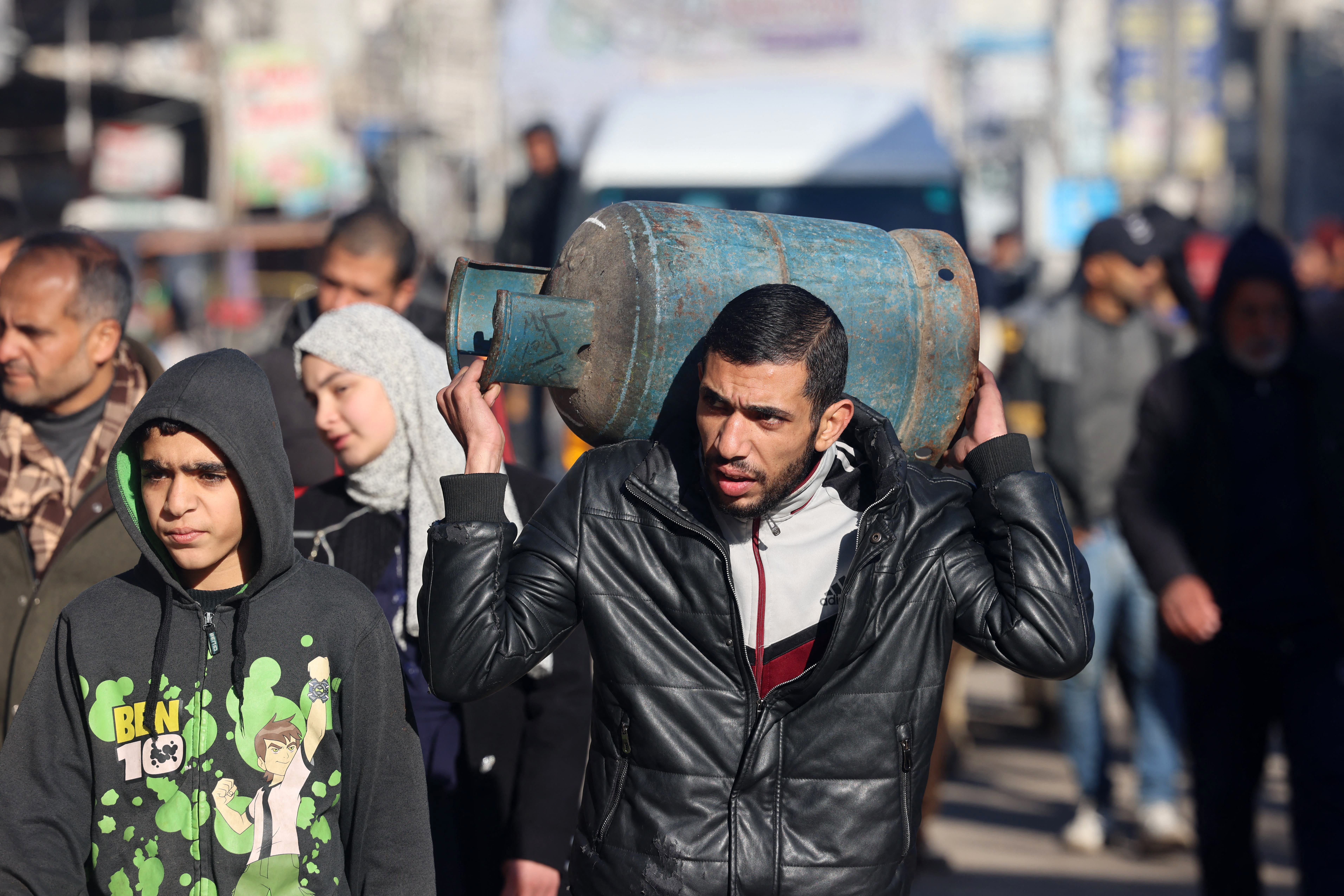 A man carries a gas canister in Rafah in the southern Gaza Strip on February 4