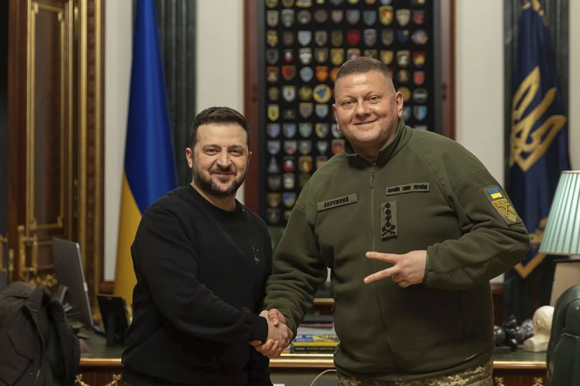 Zelenskyy, left, shakes hands with Zaluzhnyi on February 8, 2024; just days later, the latter has been replaced by Syrskyi [Ukrainian Presidential Press Office via AP]