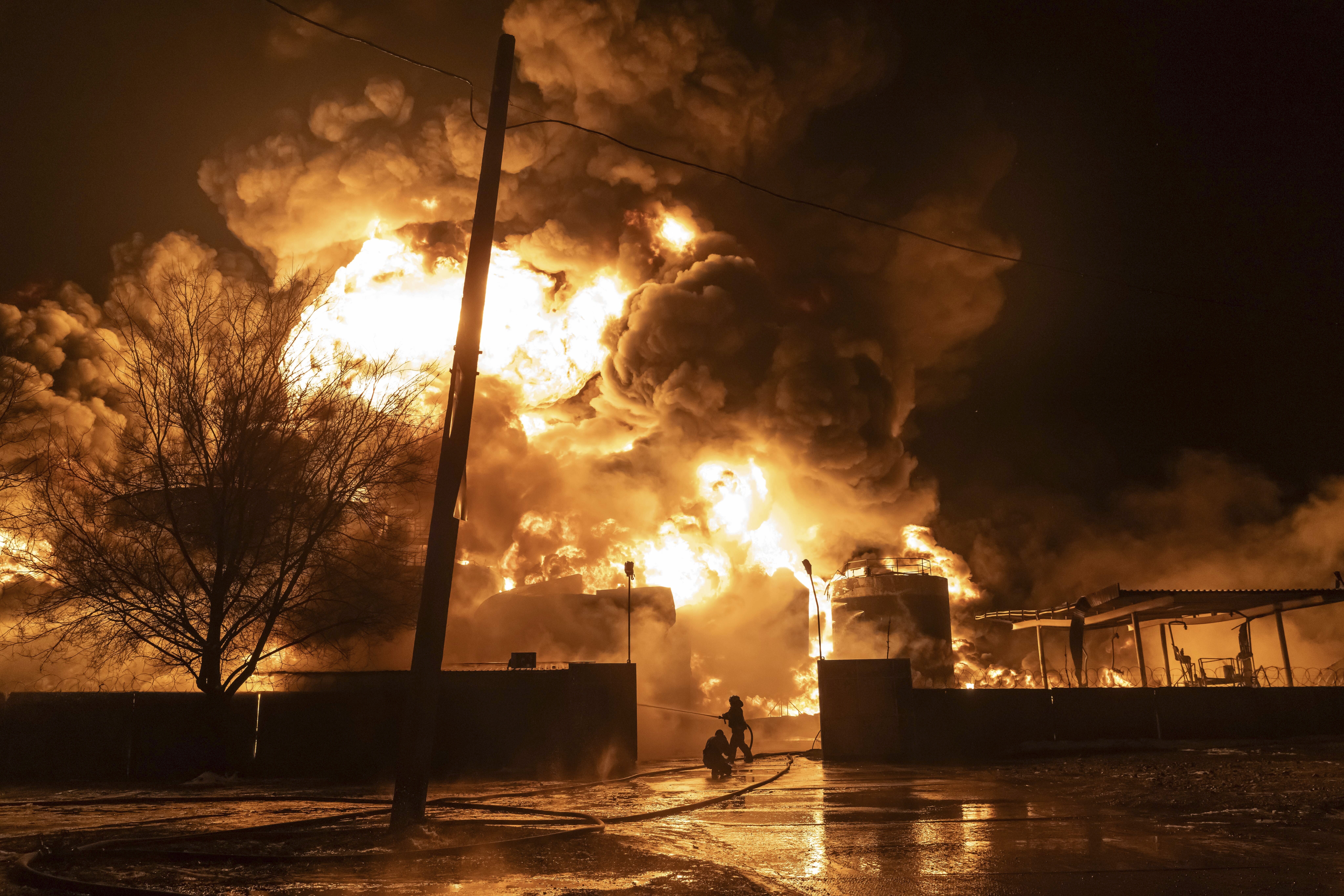 Firefighters at the petrol station thst was hit in a Russian attack. There are towering orange flames