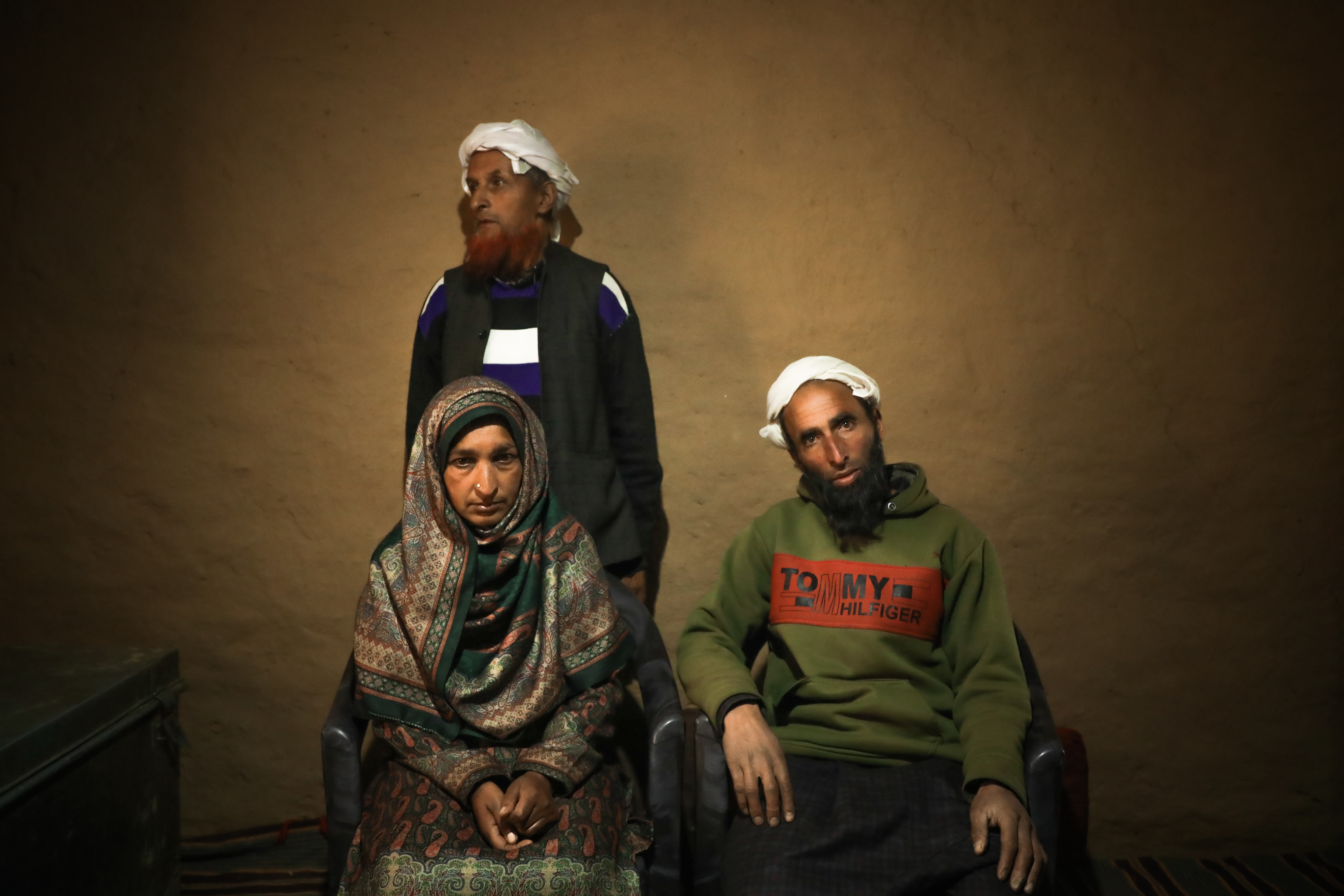Misra Begum and Muhammad Sharief, the parents of the bride, sit in front of the groom's father, Ghulam Khan, after the marriage-fixing ceremony has finished