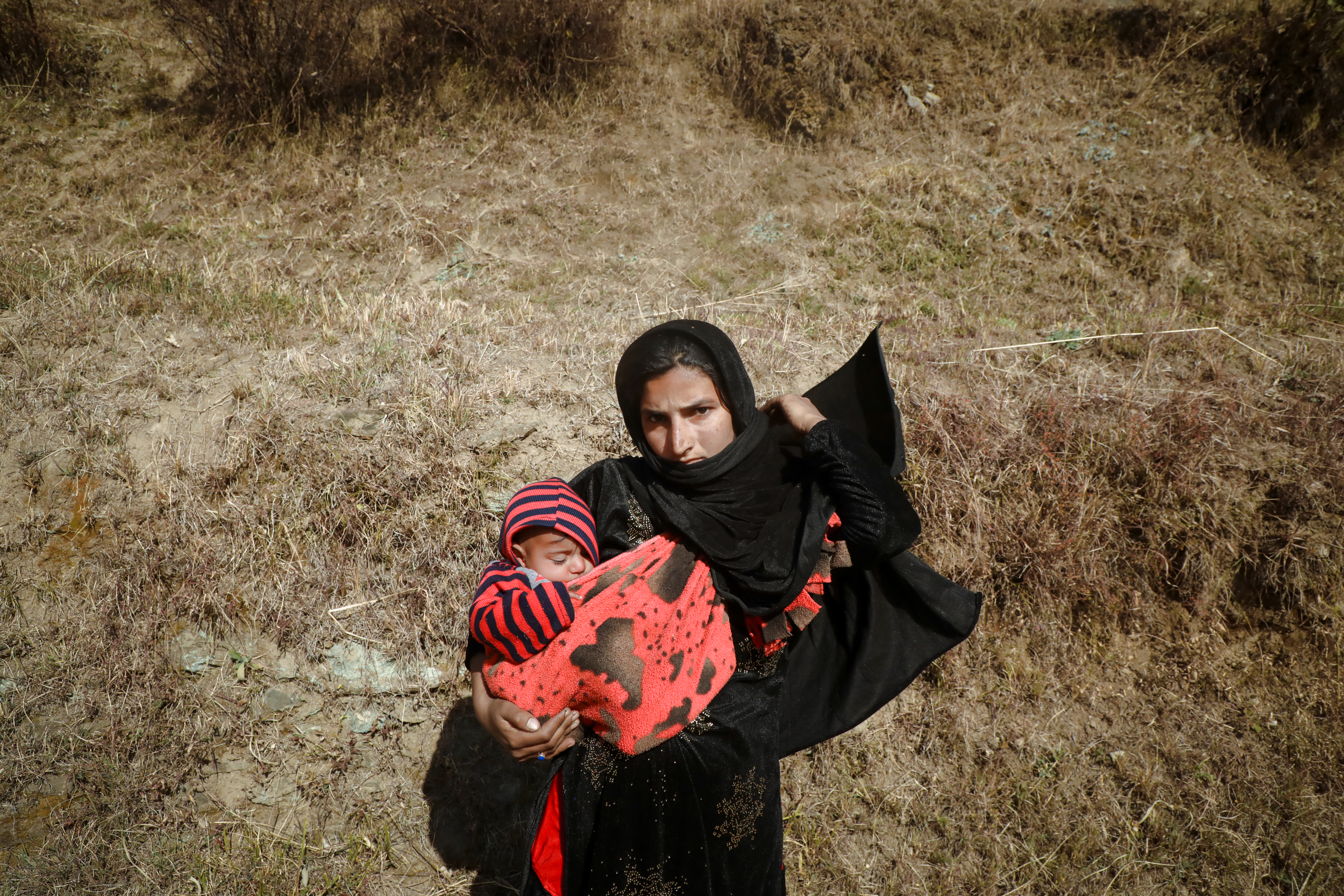 Pyaro Banu, 20, holds her toddler, Shereen, while she pays a visit to her home village of Dadkhai. Her family migrated to Punjab, India, some time ago
