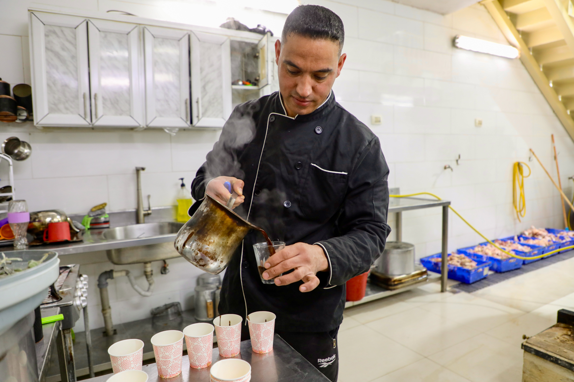 A member of the team prepares coffee for his hard-working colleagues